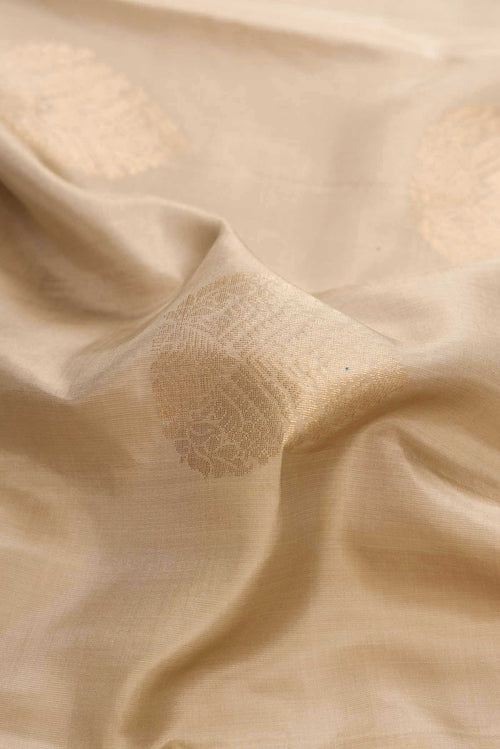 Close up of Beige Dual Tone Soft Silk Saree with Zari Butta on the body and Zari Border displaying folds