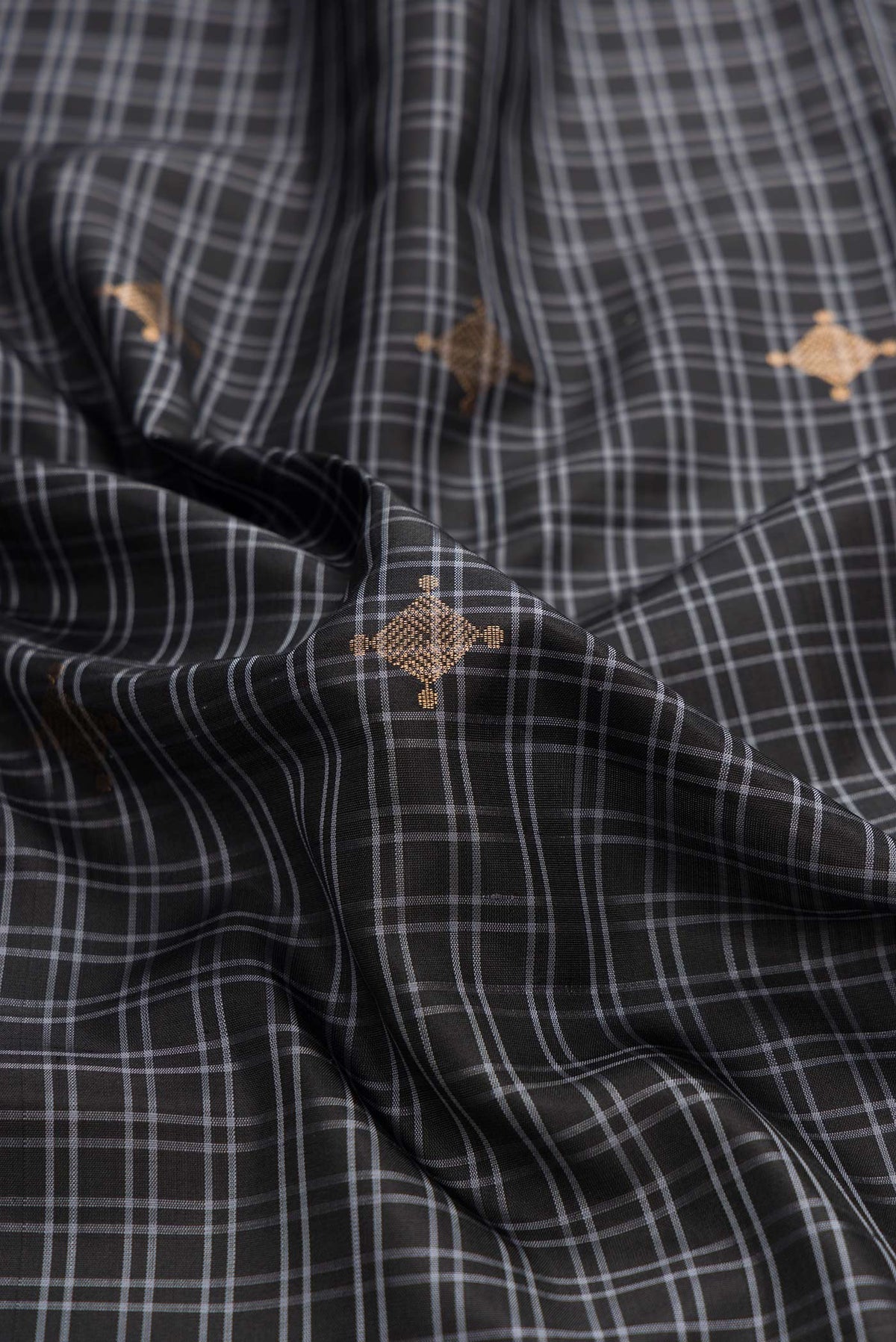 Close up of Black Dual Tone Soft Silk Saree with Checked design on the body and Zari Border displaying folds