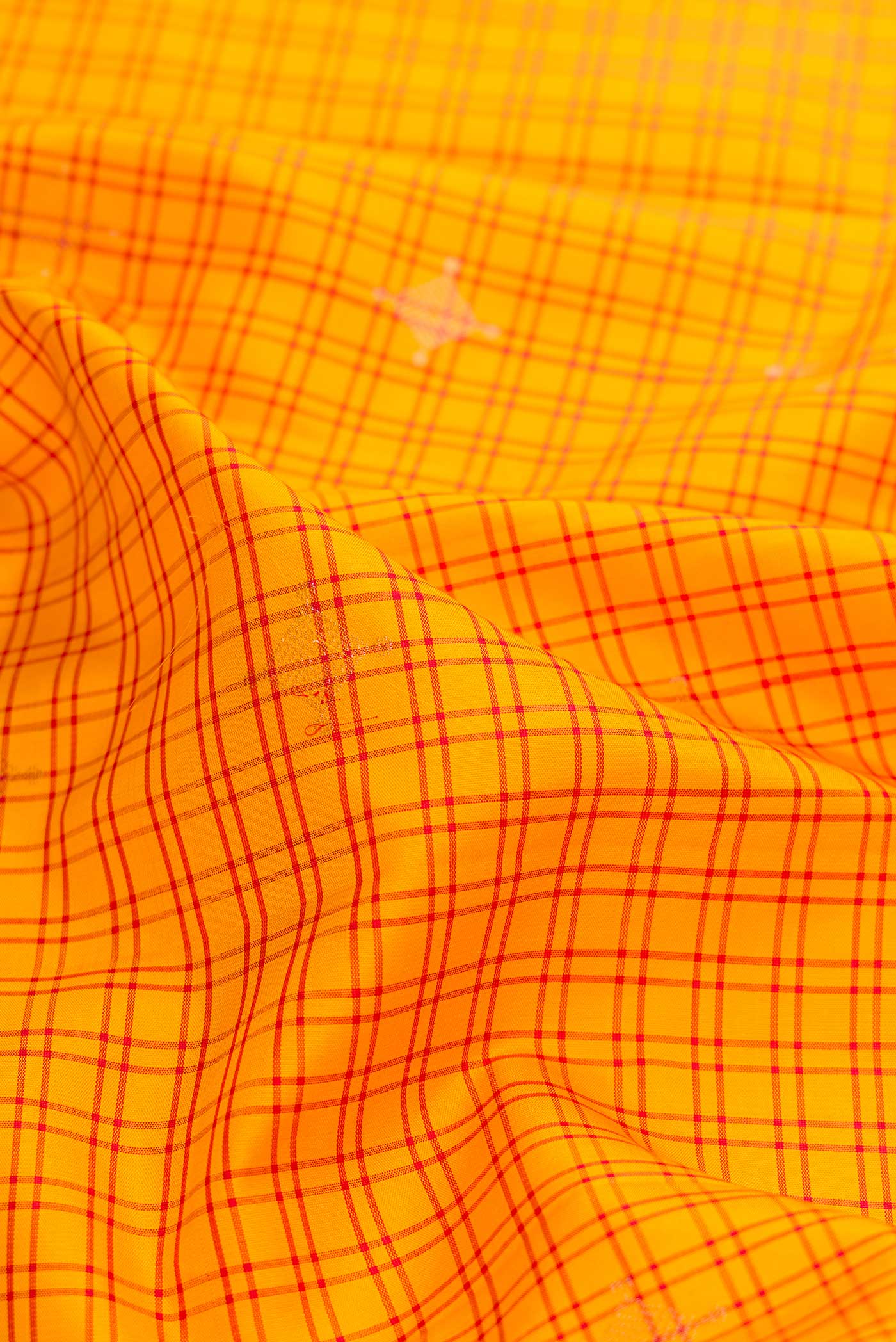 Close up of Yellow Soft Silk Saree with Checked design on the body and Thread Border displaying folds