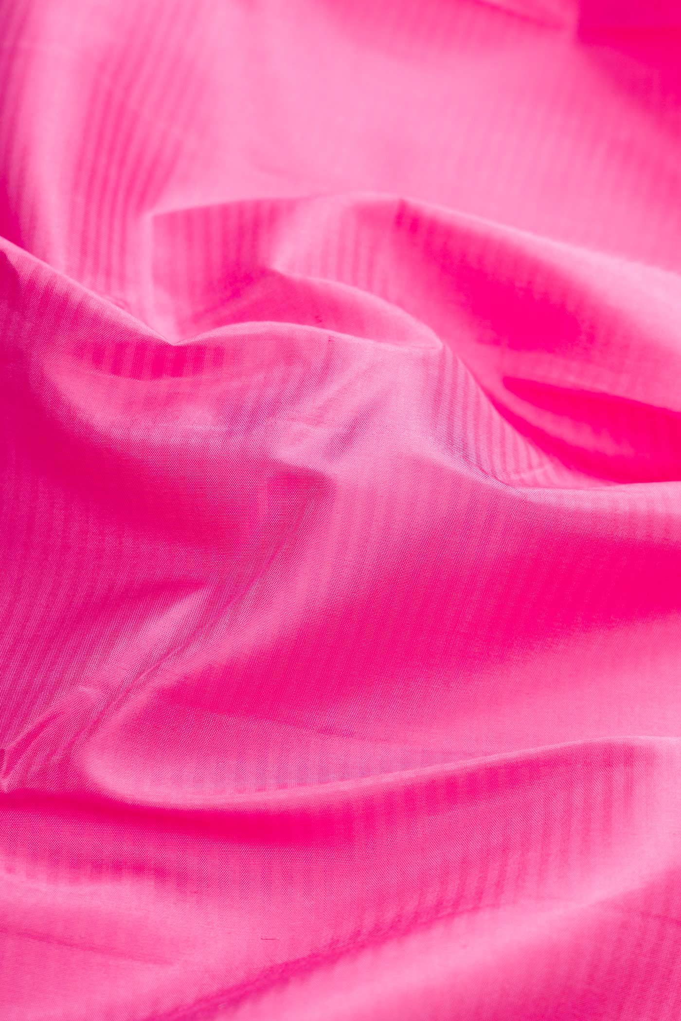 Close up of Pink Dual Tone Kanchipuram Silk Saree with Stripes on the body and Zari Border displaying folds