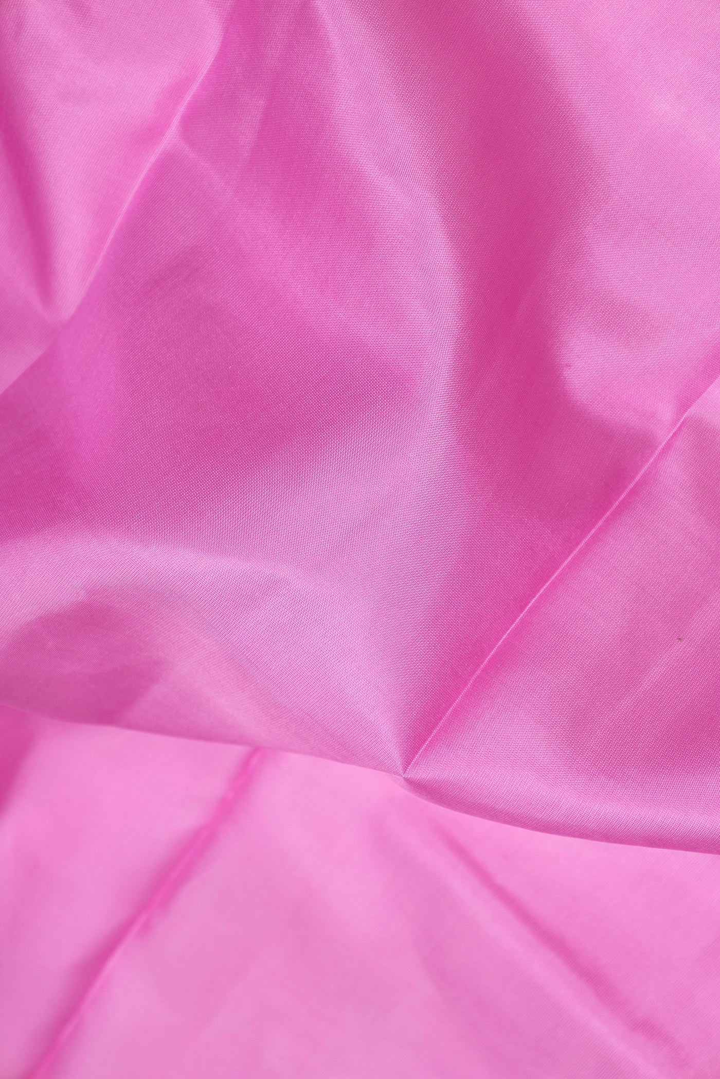 Close up of Pink Dual Tone Kanchipuram Silk Saree with Zari Butta on the body and Zari Border.  displaying folds
