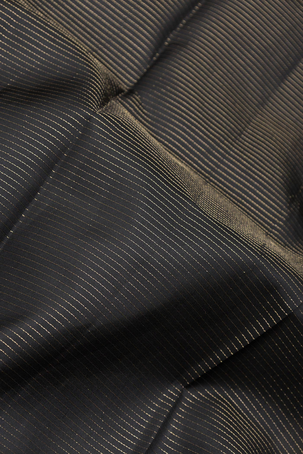 Close up of Black Dual Tone Kanchipuram Silk Saree with Stripes on the body and Zari Border.  displaying folds