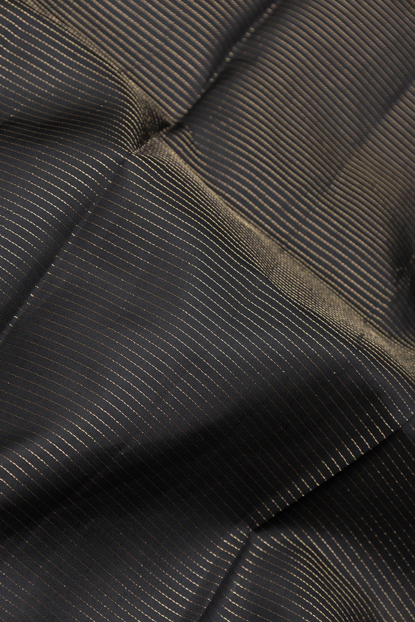 Close up of Black Dual Tone Kanchipuram Silk Saree with Stripes on the body and Zari Border.  displaying folds