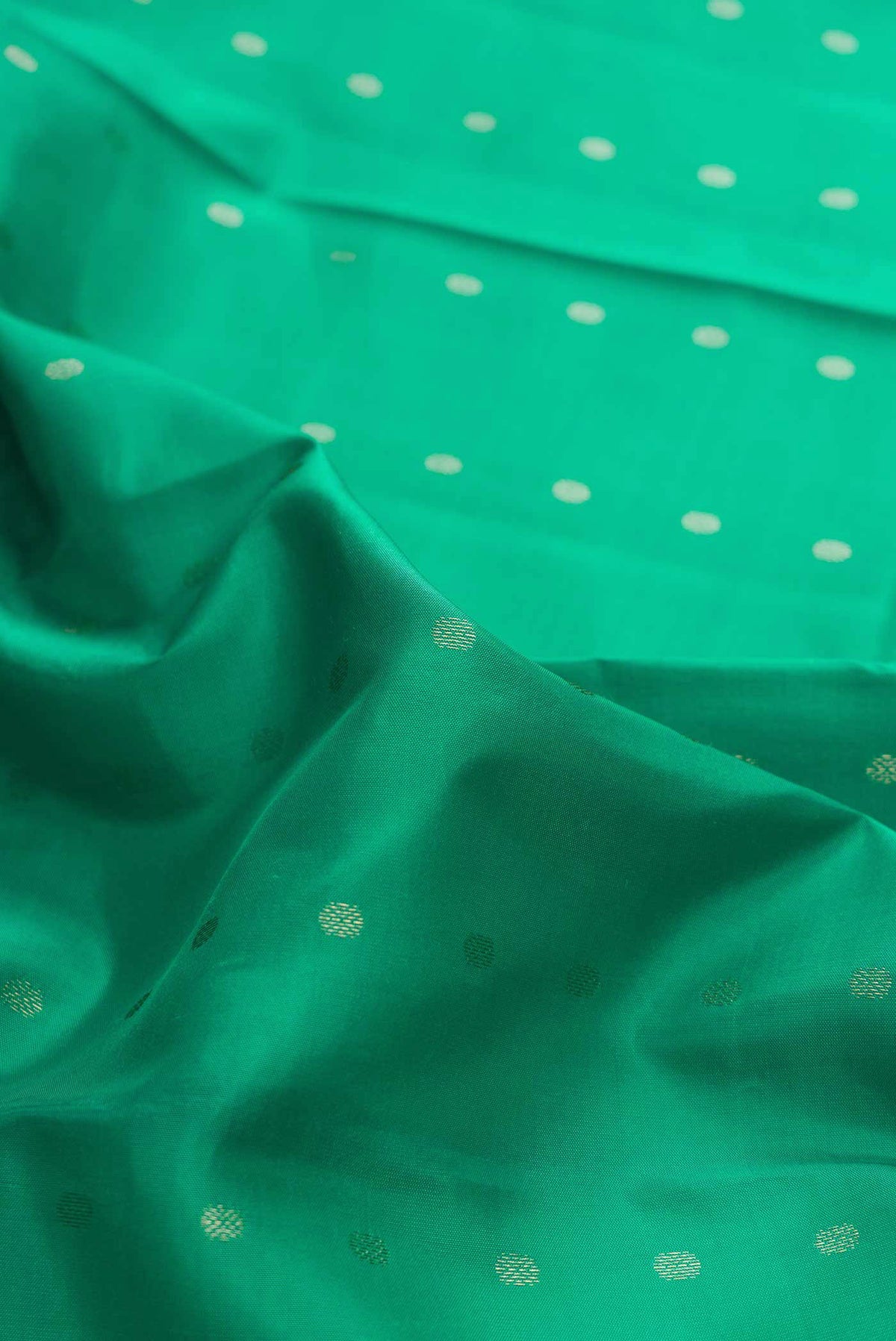 Close up of Green Dual Tone Kanchipuram Silk Saree with Zari Butta on the body and Zari Border displaying folds