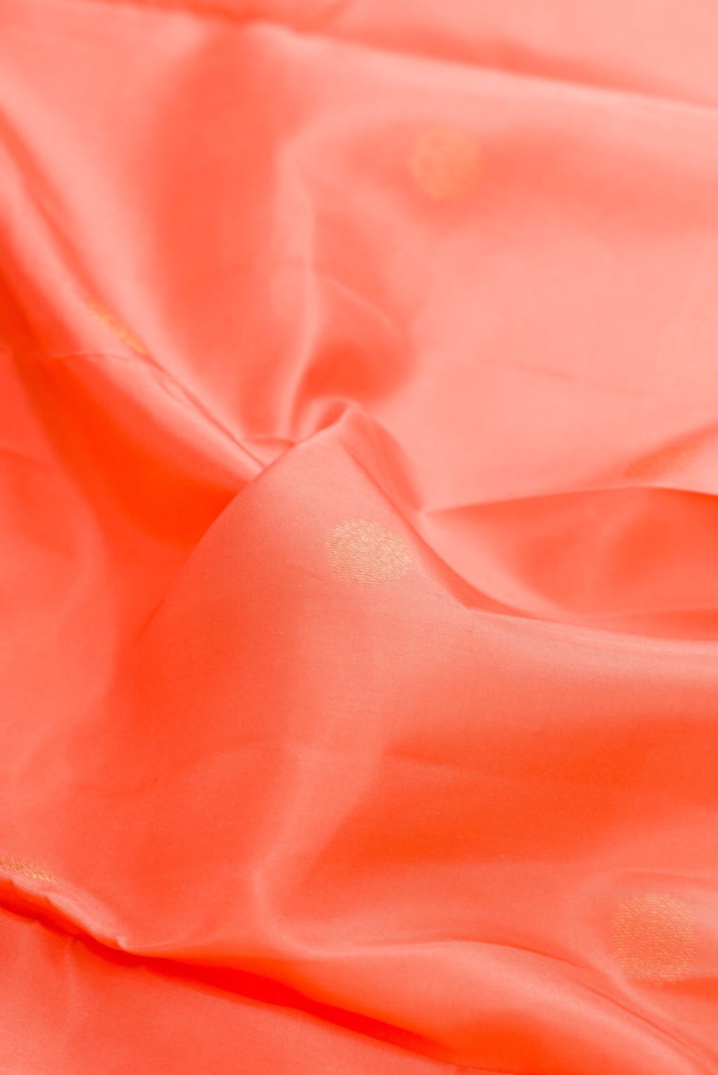 Close up of Orange Kanchipuram Silk Saree with Zari Butta on the body and Zari Border displaying folds
