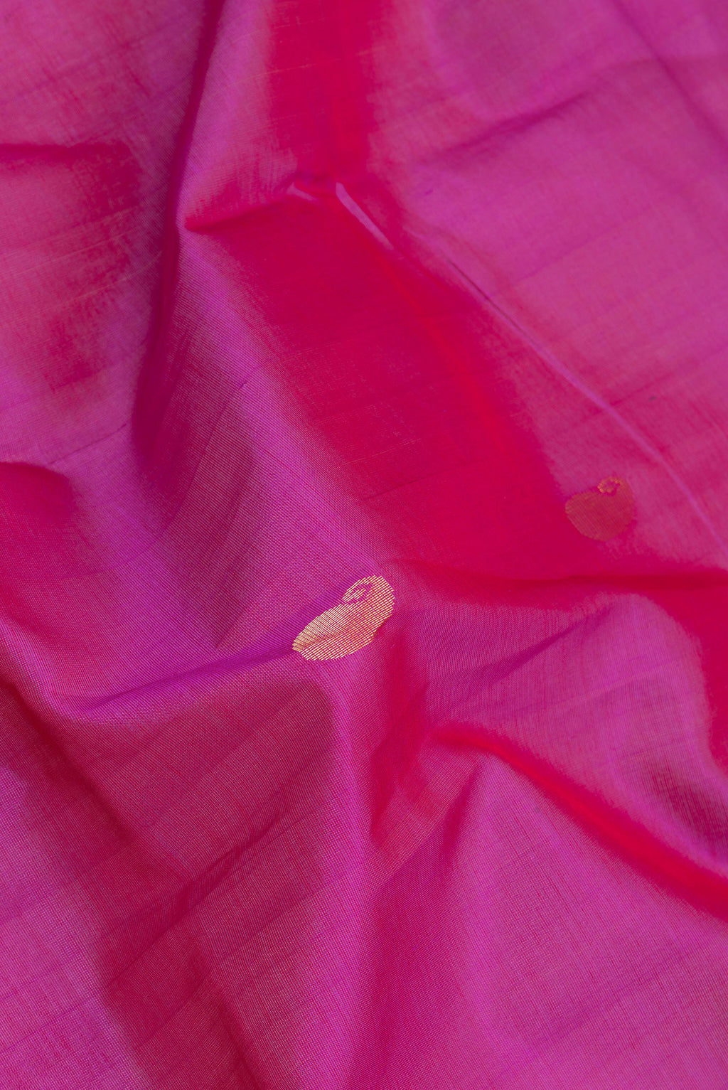 Close up of Dark Pink Silk Cotton Saree with Zari Butta on the body and Zari Border.  displaying folds