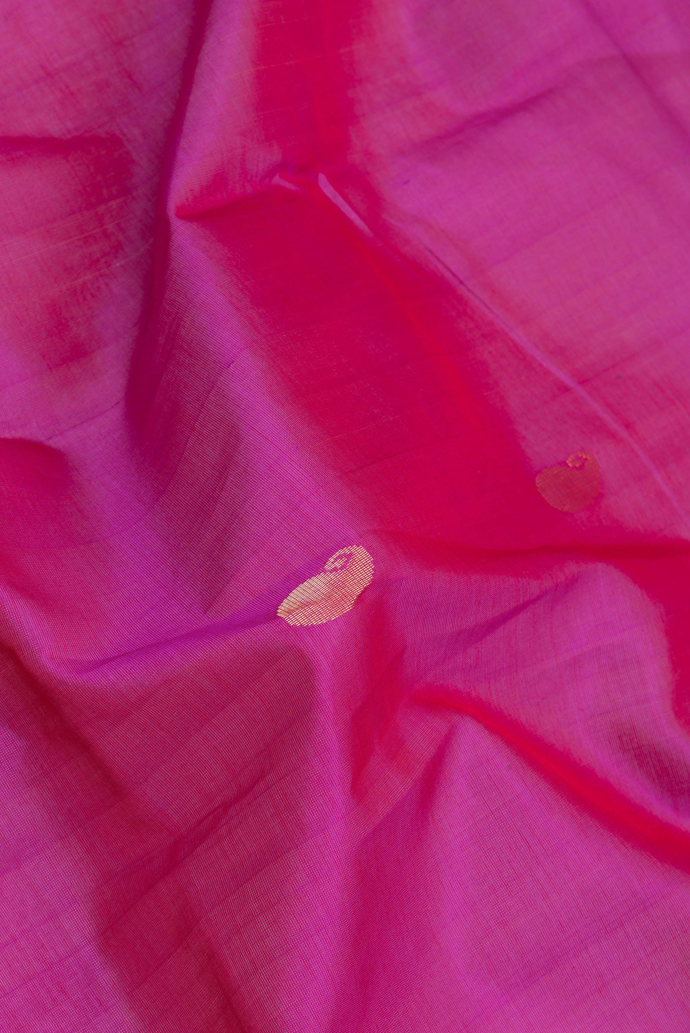 Close up of Dark Pink Silk Cotton Saree with Zari Butta on the body and Zari Border.  displaying folds