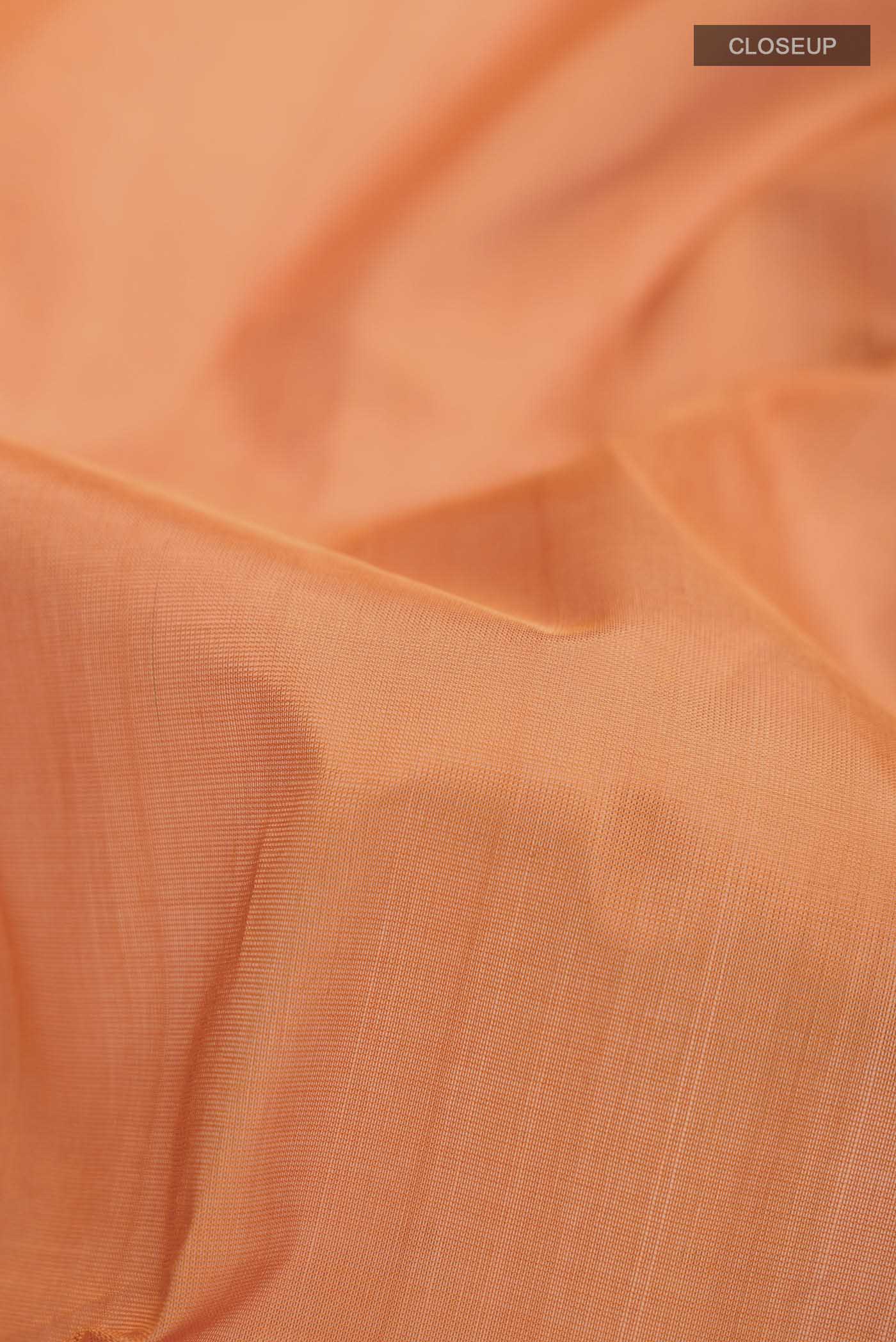 Close up of Orange Silk Cotton Saree with Plain Body and Zari Border displaying folds