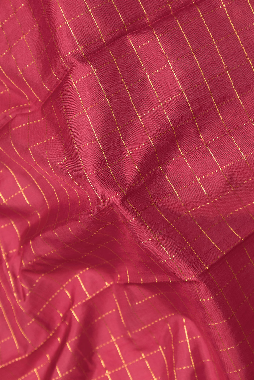 Close up of Maroon Kanchipuram Silk Saree with Checked design on the body and Zari Border.  displaying folds