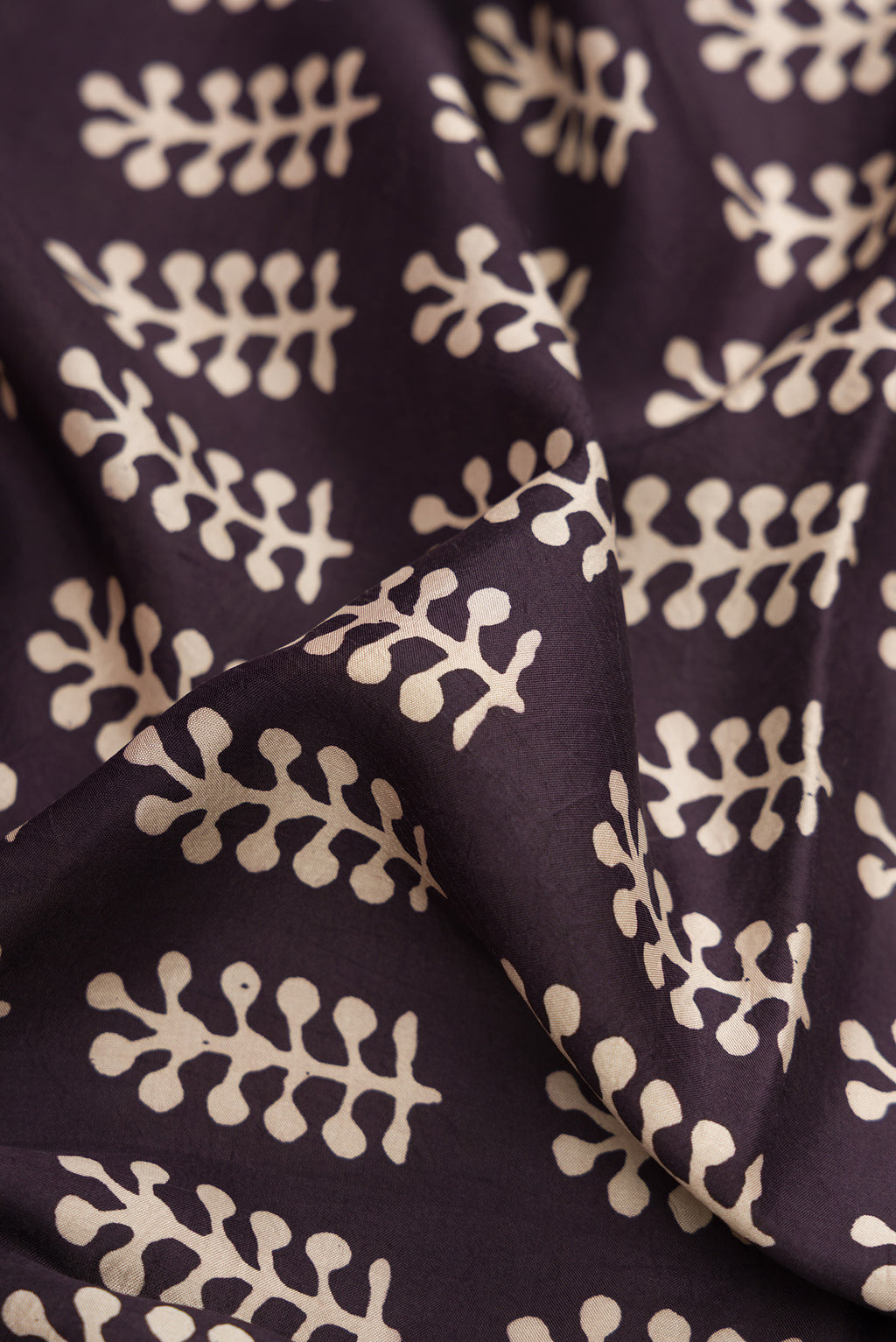 Close up of Black Printed Silk Saree with Printed design on the body and Printed Border.  displaying folds