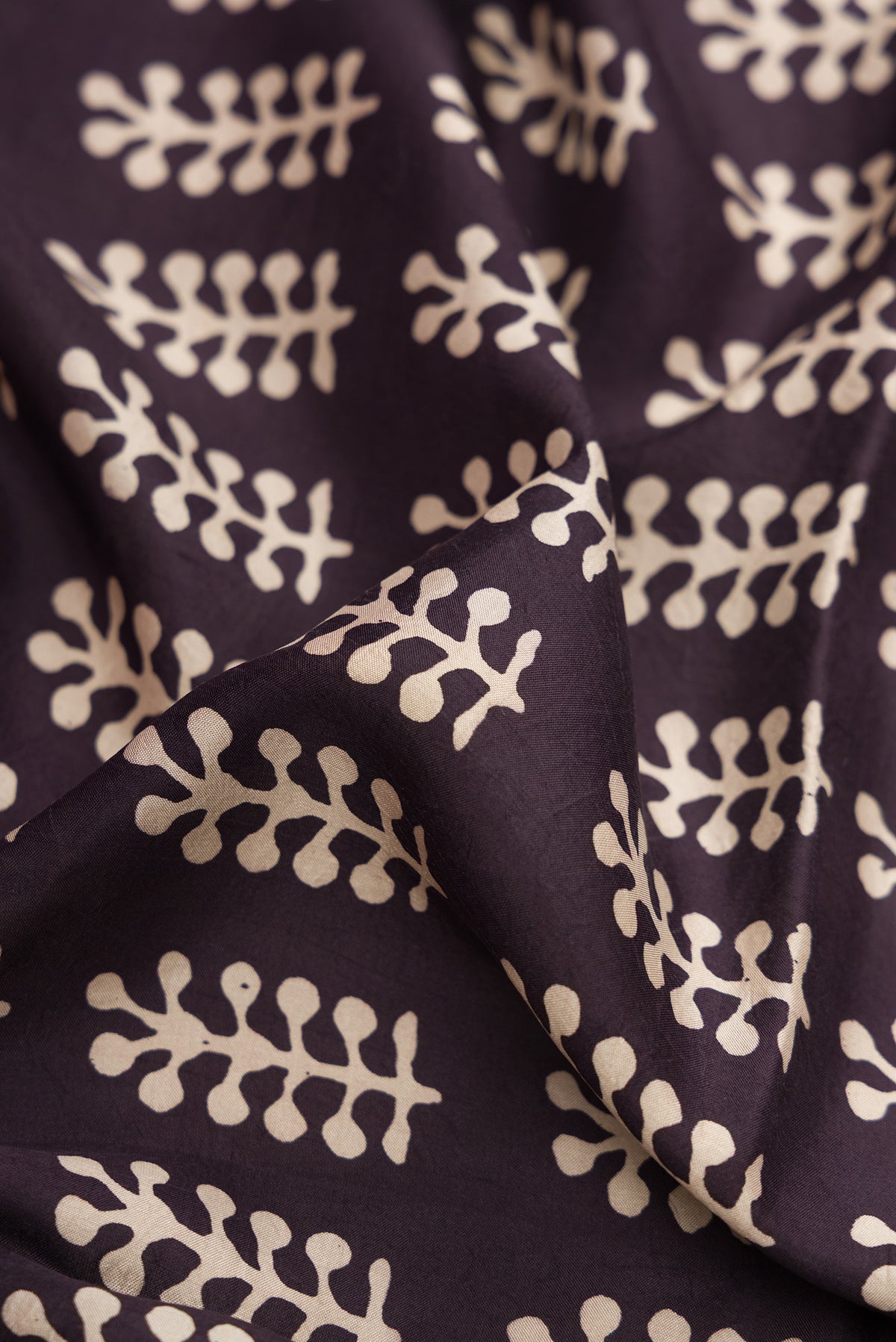 Close up of Black Printed Silk Saree with Printed design on the body and Printed Border.  displaying folds