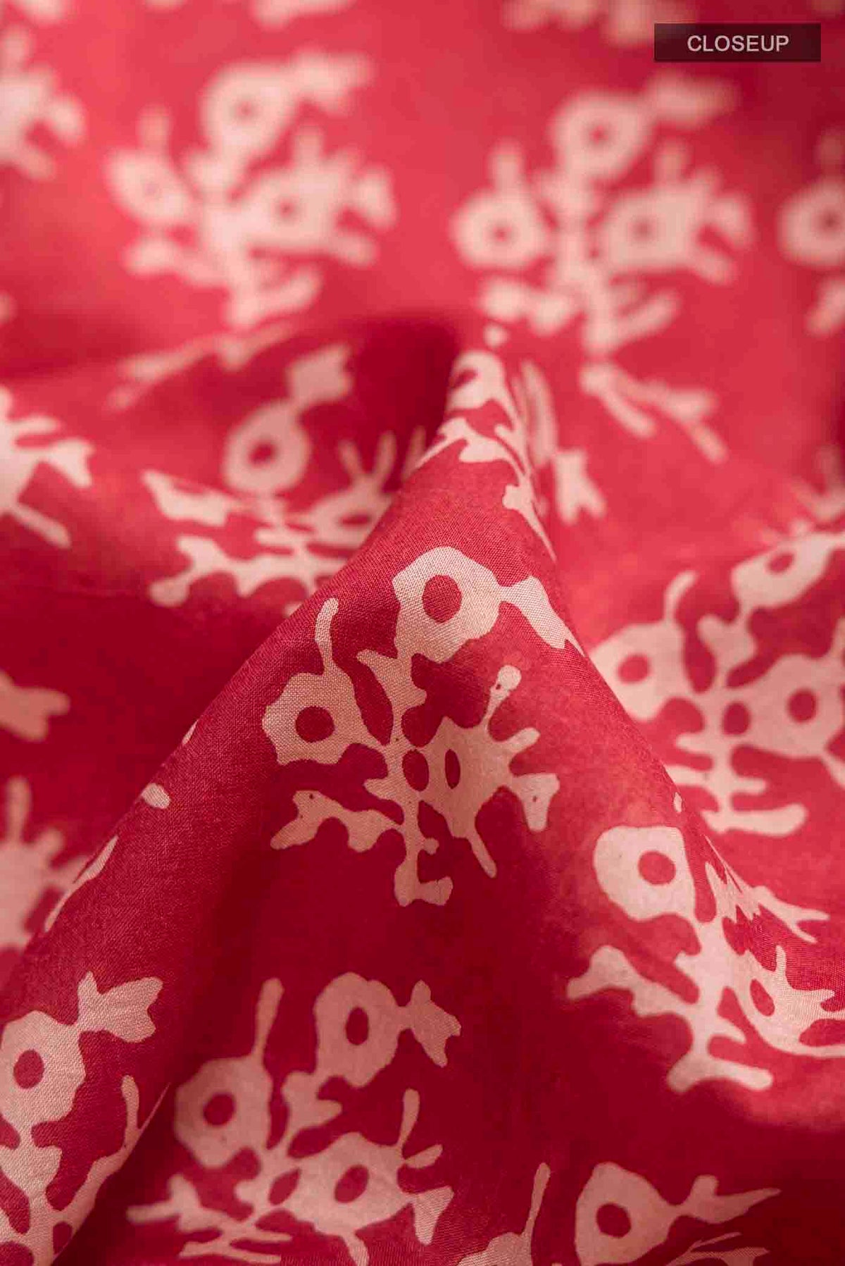 Close up of Rust Printed Silk Saree with Printed design on the body and Printed Border displaying folds