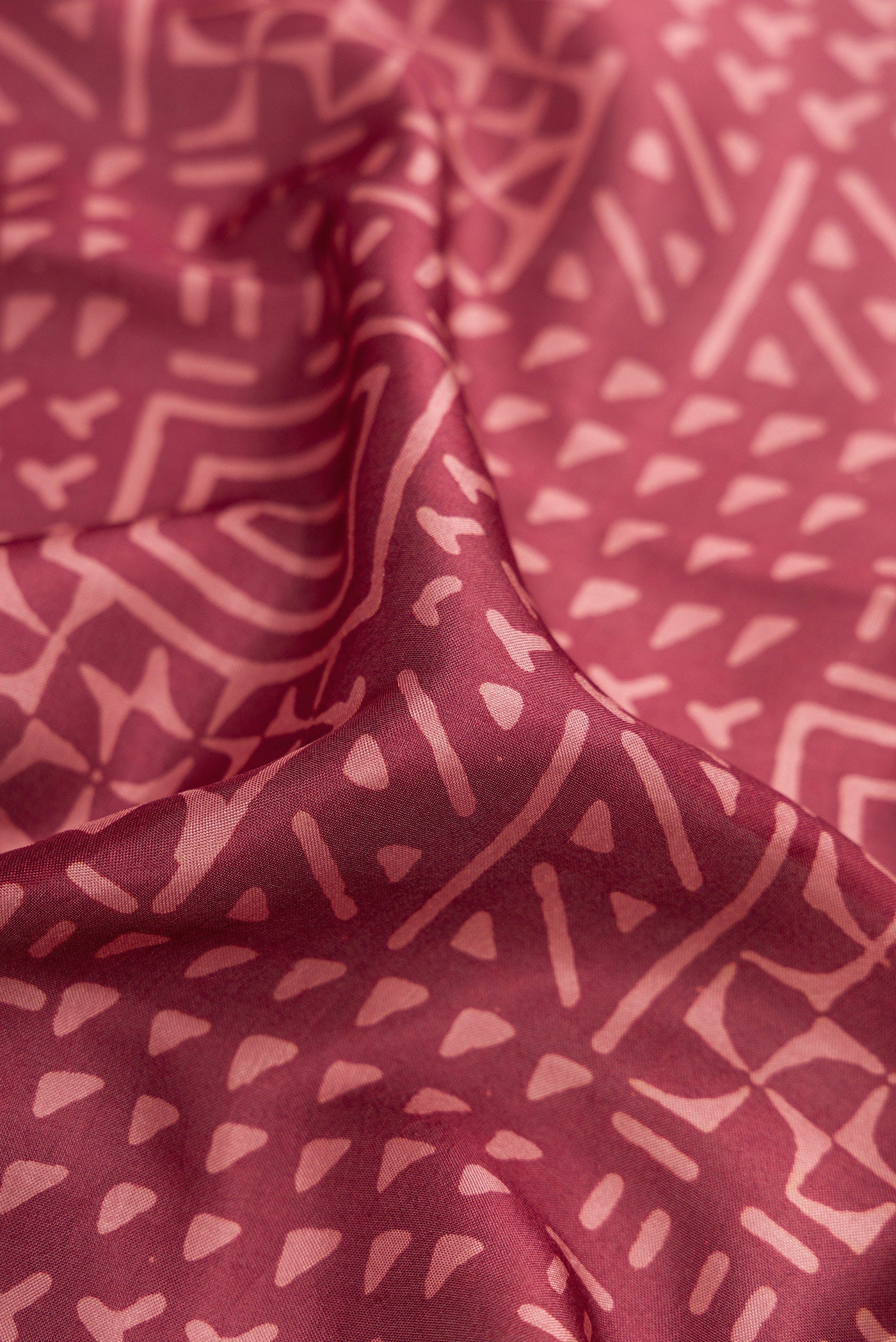 Close up of Maroon Printed Silk Saree with Printed design on the body and Printed Border.  displaying folds