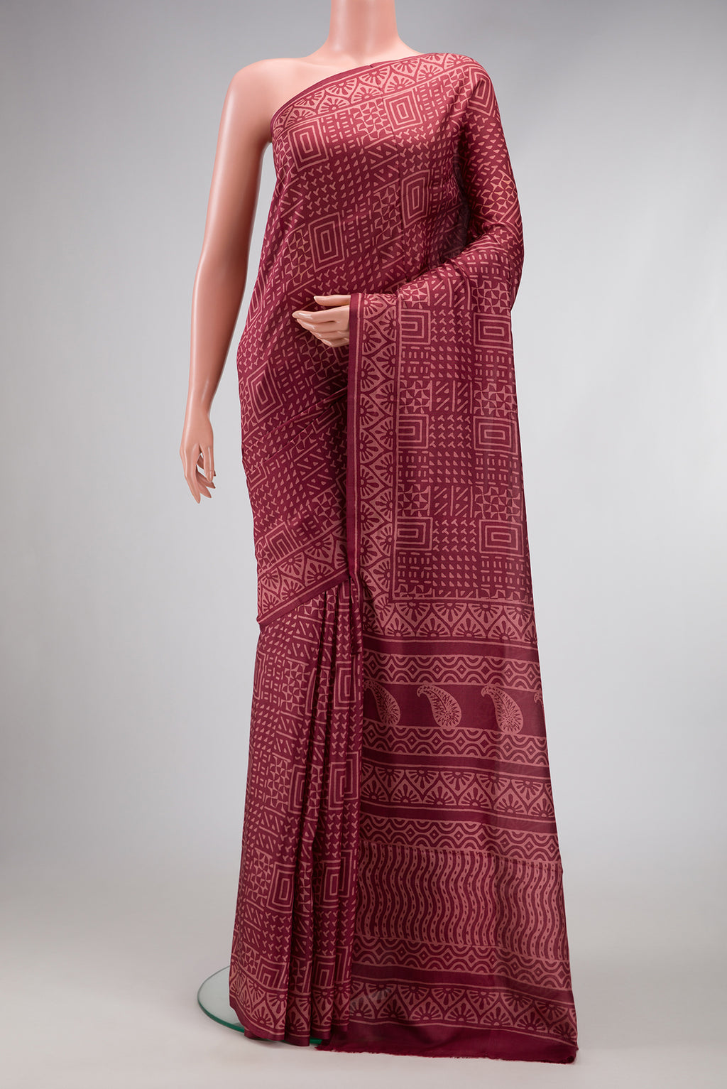 Maroon Printed Silk Saree with Printed design on the body and Printed Border.  displayed on a mannequin
