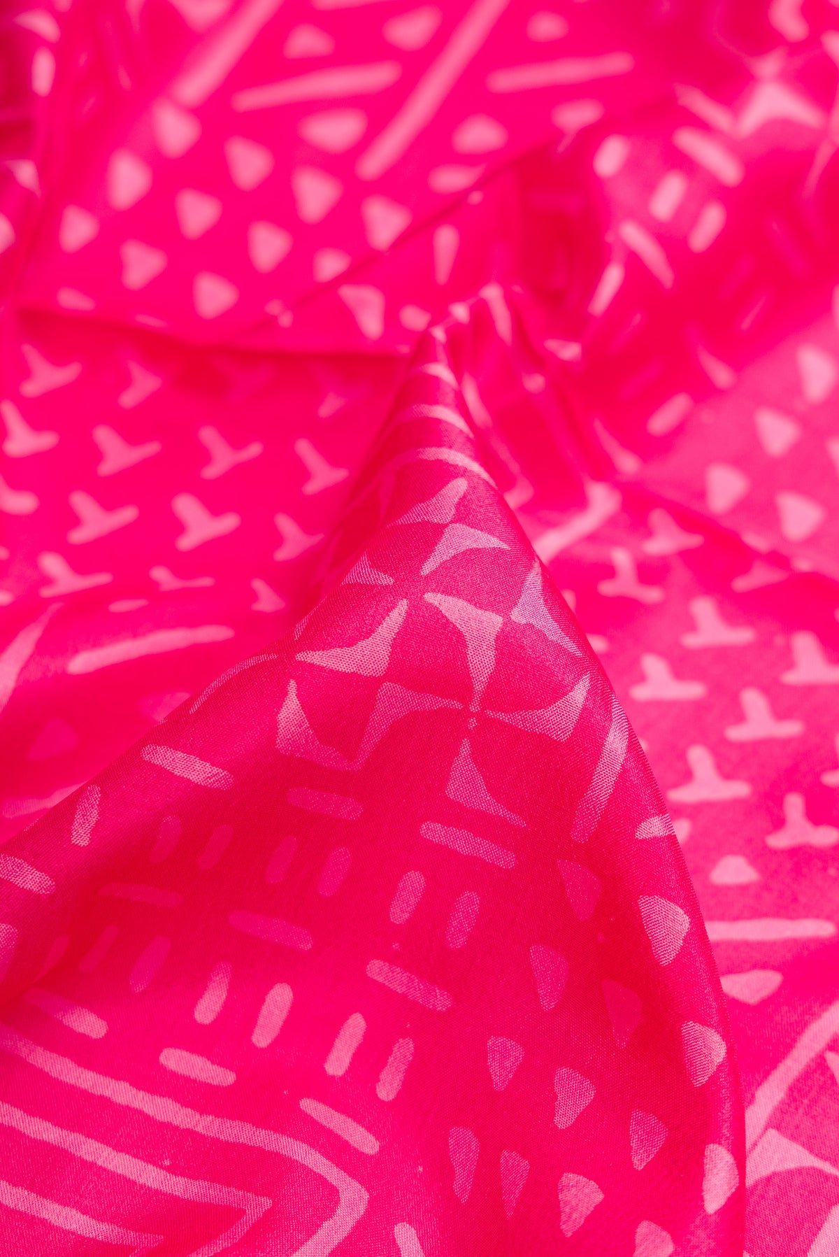 Close up of Pink Printed Silk Saree with Printed design on the body and Printed Border.  displaying folds