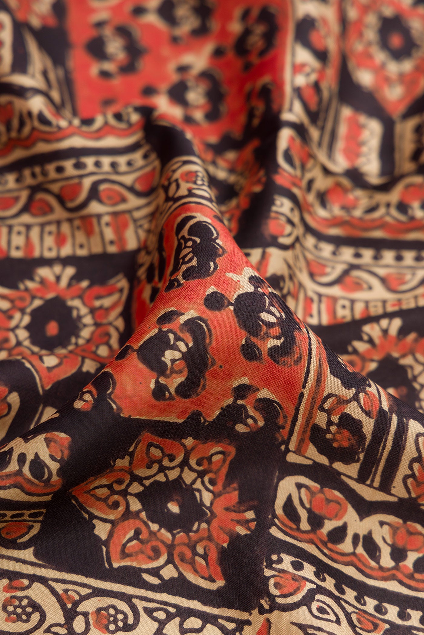 Close up of Black Printed Silk Saree with Printed design on the body and Printed Border.  displaying folds