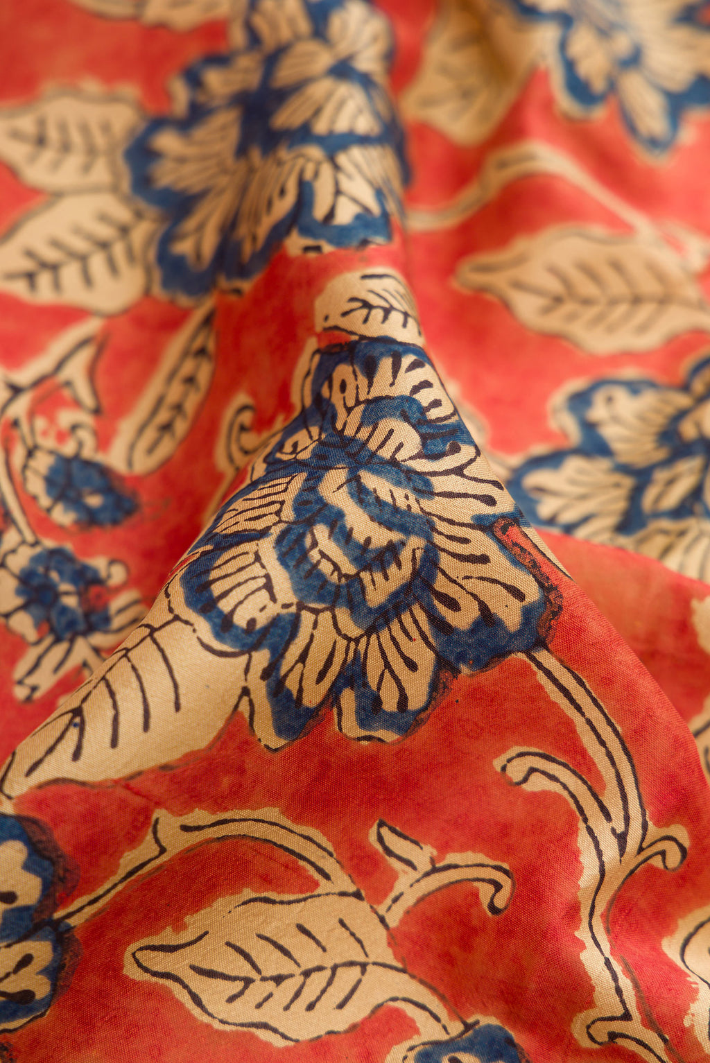 Close up of Orange Printed Silk Saree with Printed design on the body and Printed Border.  displaying folds