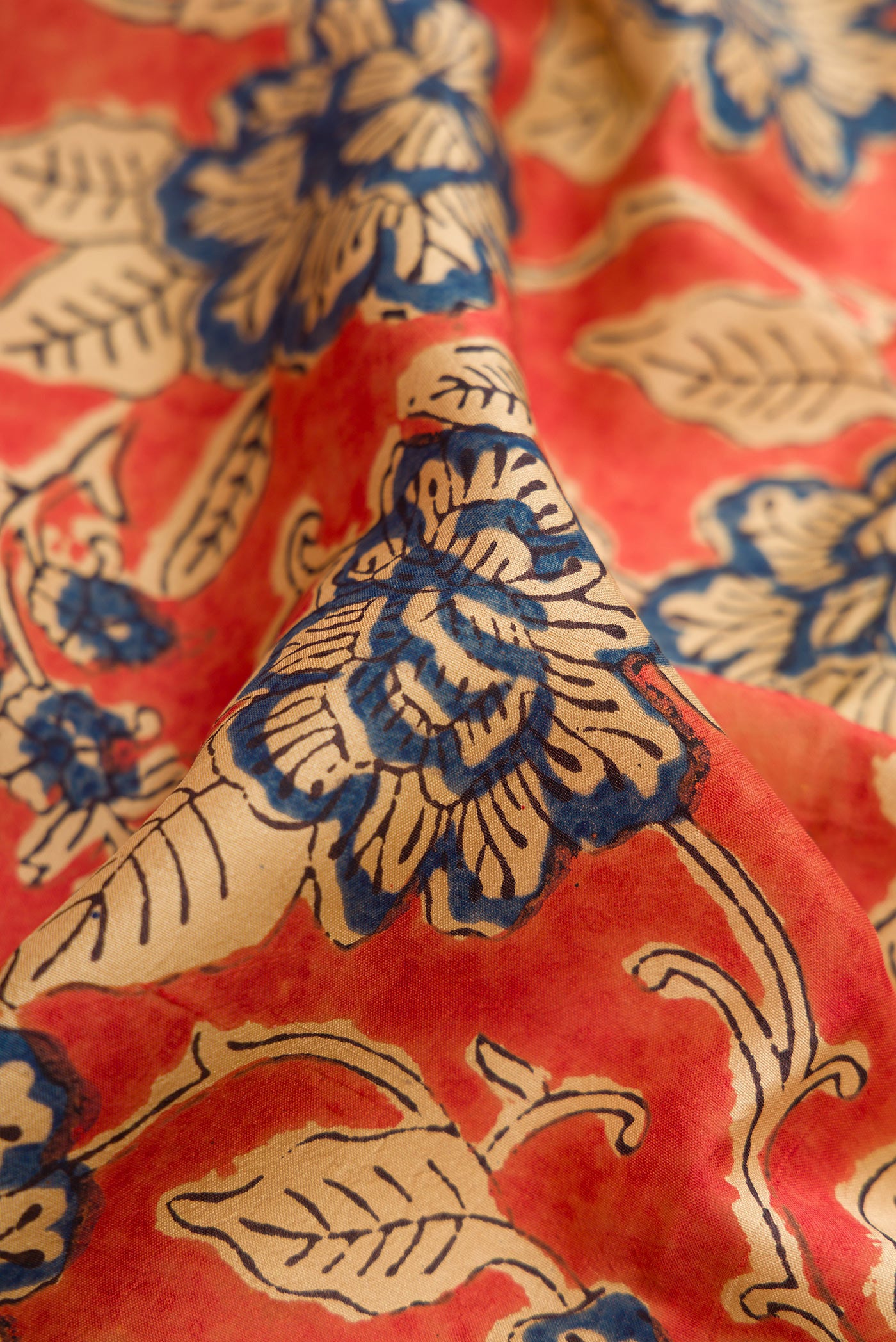 Close up of Orange Printed Silk Saree with Printed design on the body and Printed Border.  displaying folds