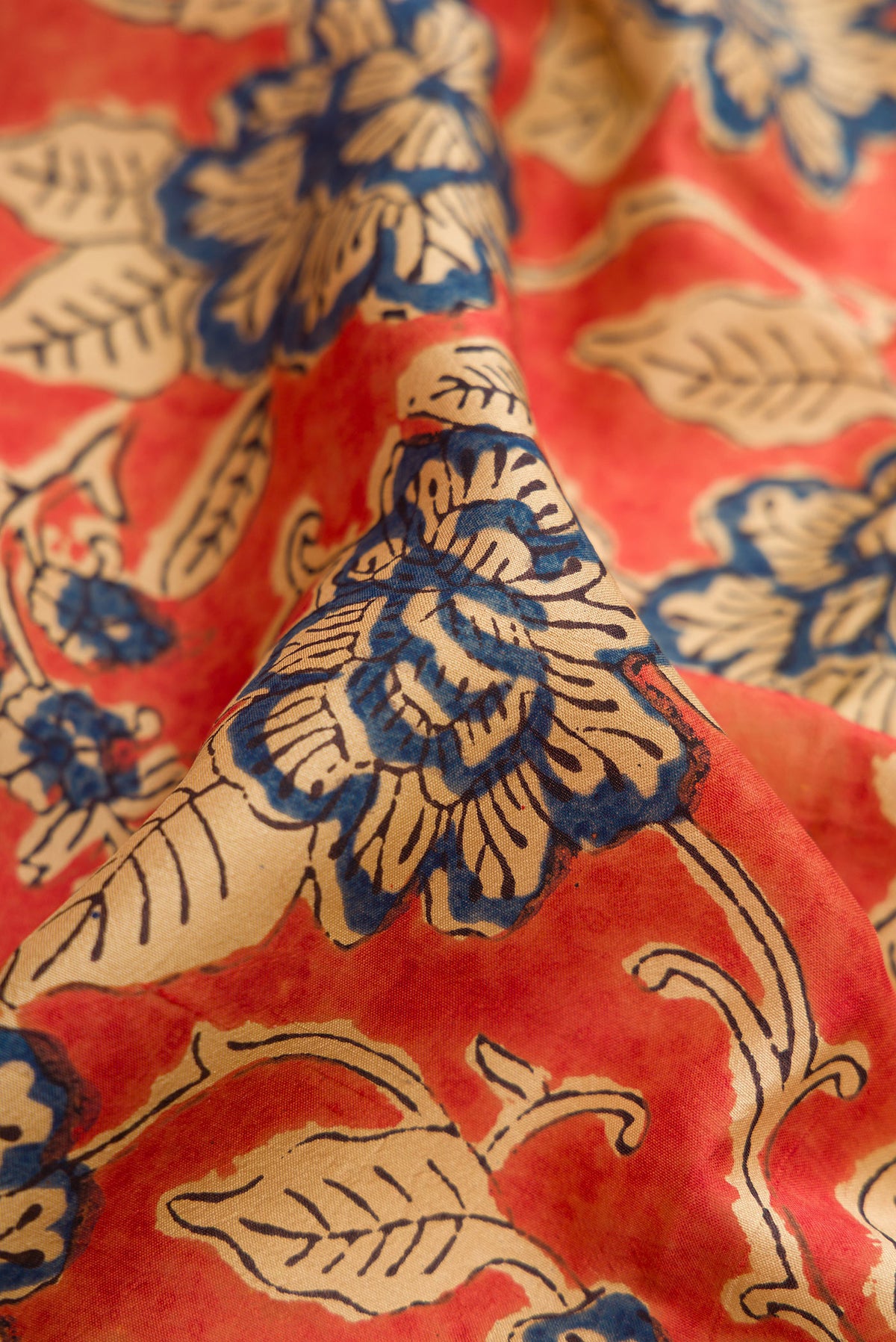 Close up of Orange Printed Silk Saree with Printed design on the body and Printed Border.  displaying folds