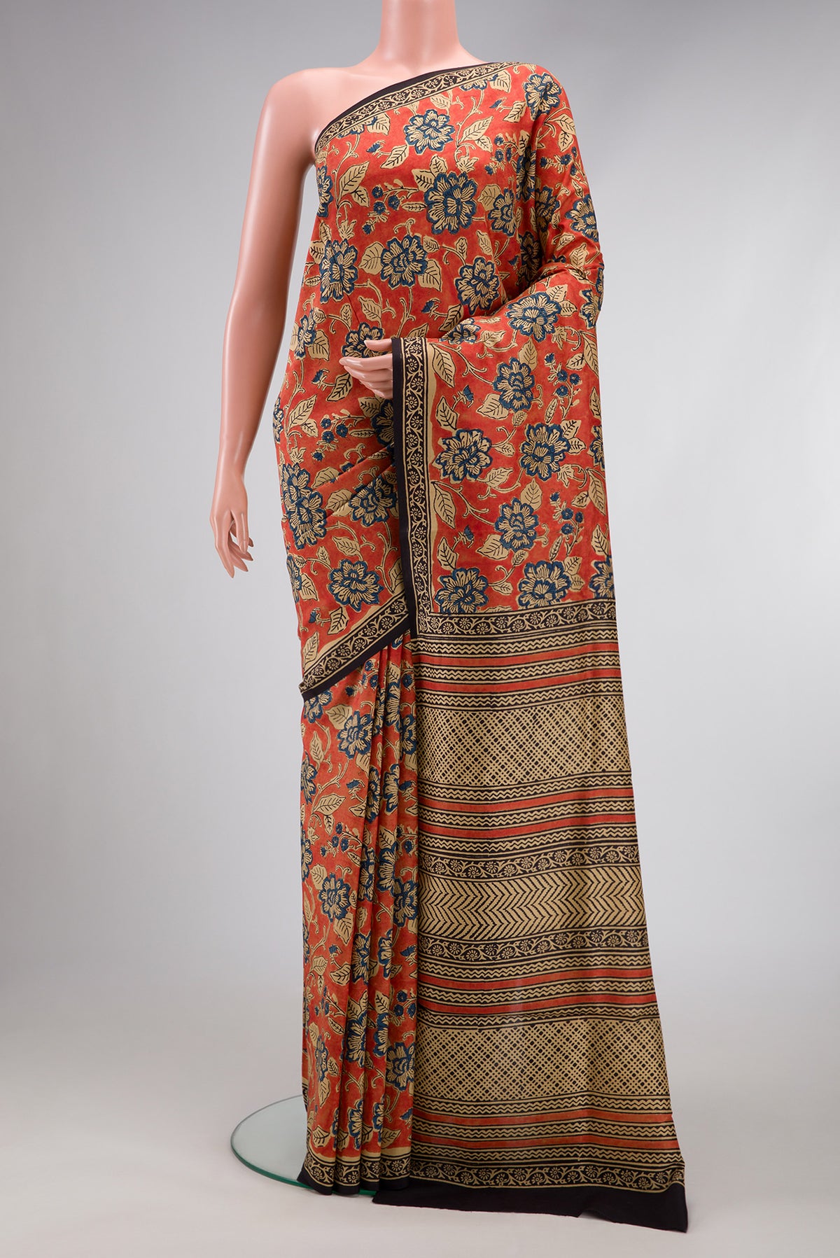 Orange Printed Silk Saree with Printed design on the body and Printed Border.  displayed on a mannequin