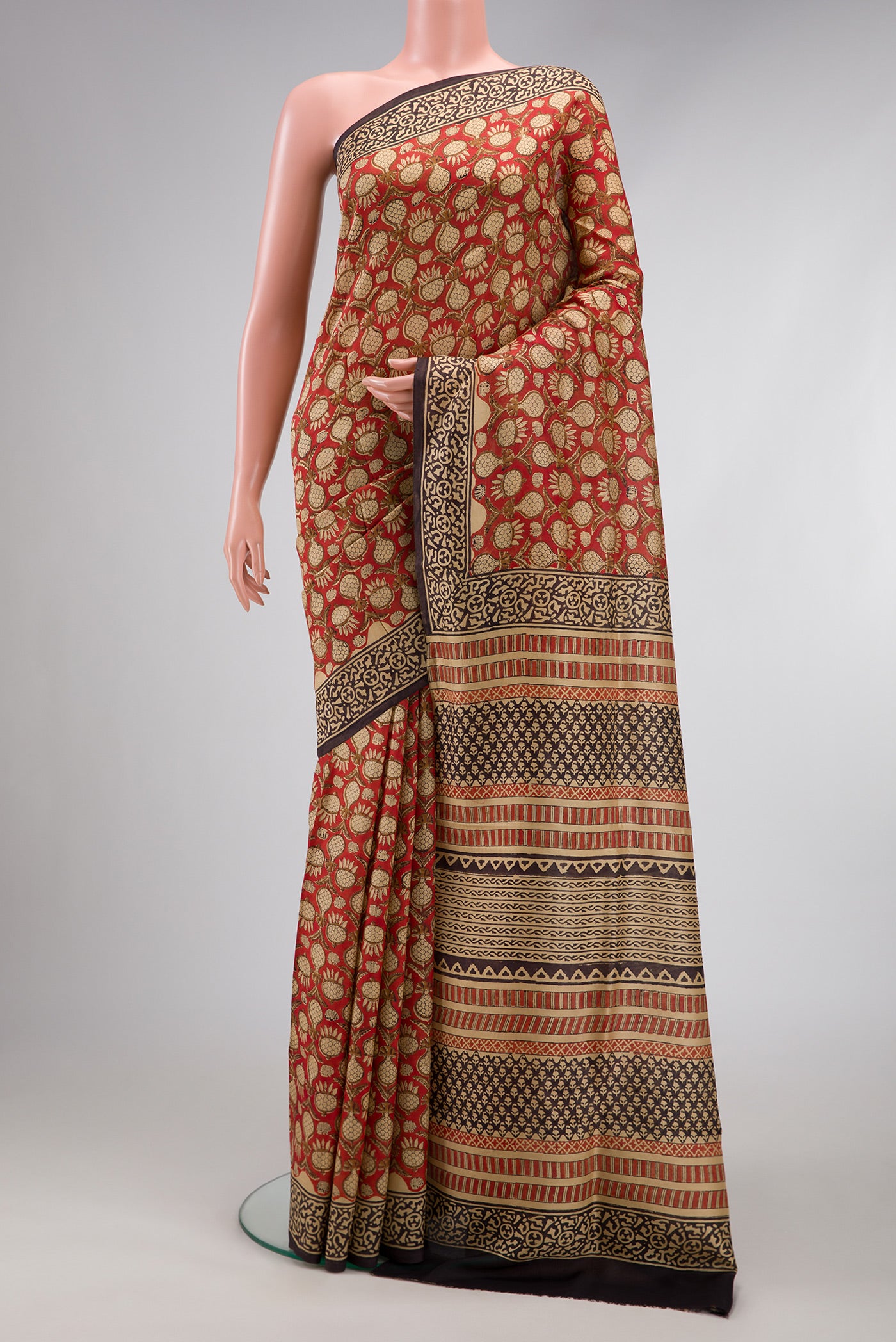 Rust Printed Silk Saree with Printed design on the body and Printed Border.  displayed on a mannequin