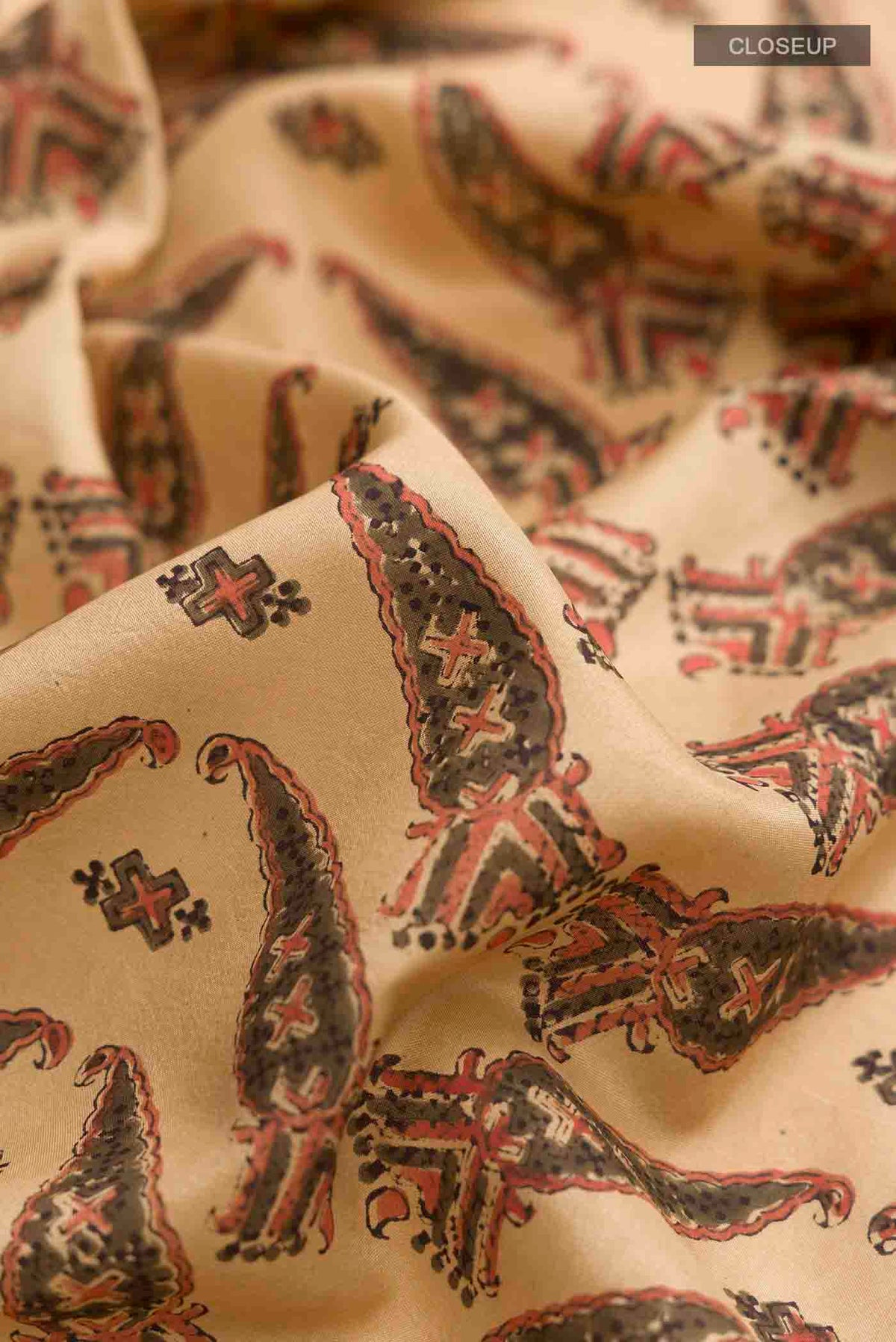 Close up of Beige Printed Silk Saree with Printed design on the body and Printed Border displaying folds