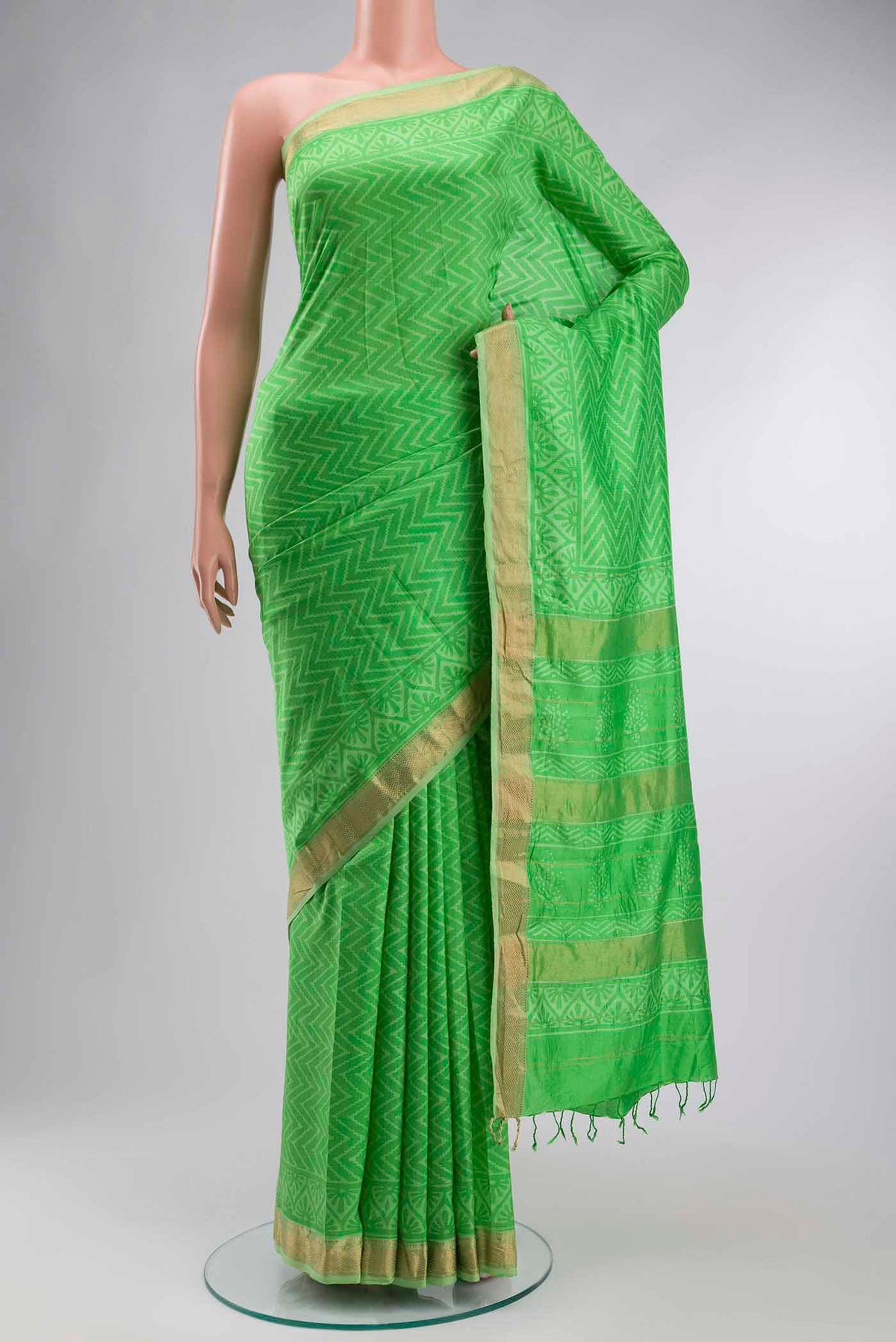 Green Printed Silk Saree with Printed design on the body and Zari Border displayed on a mannequin