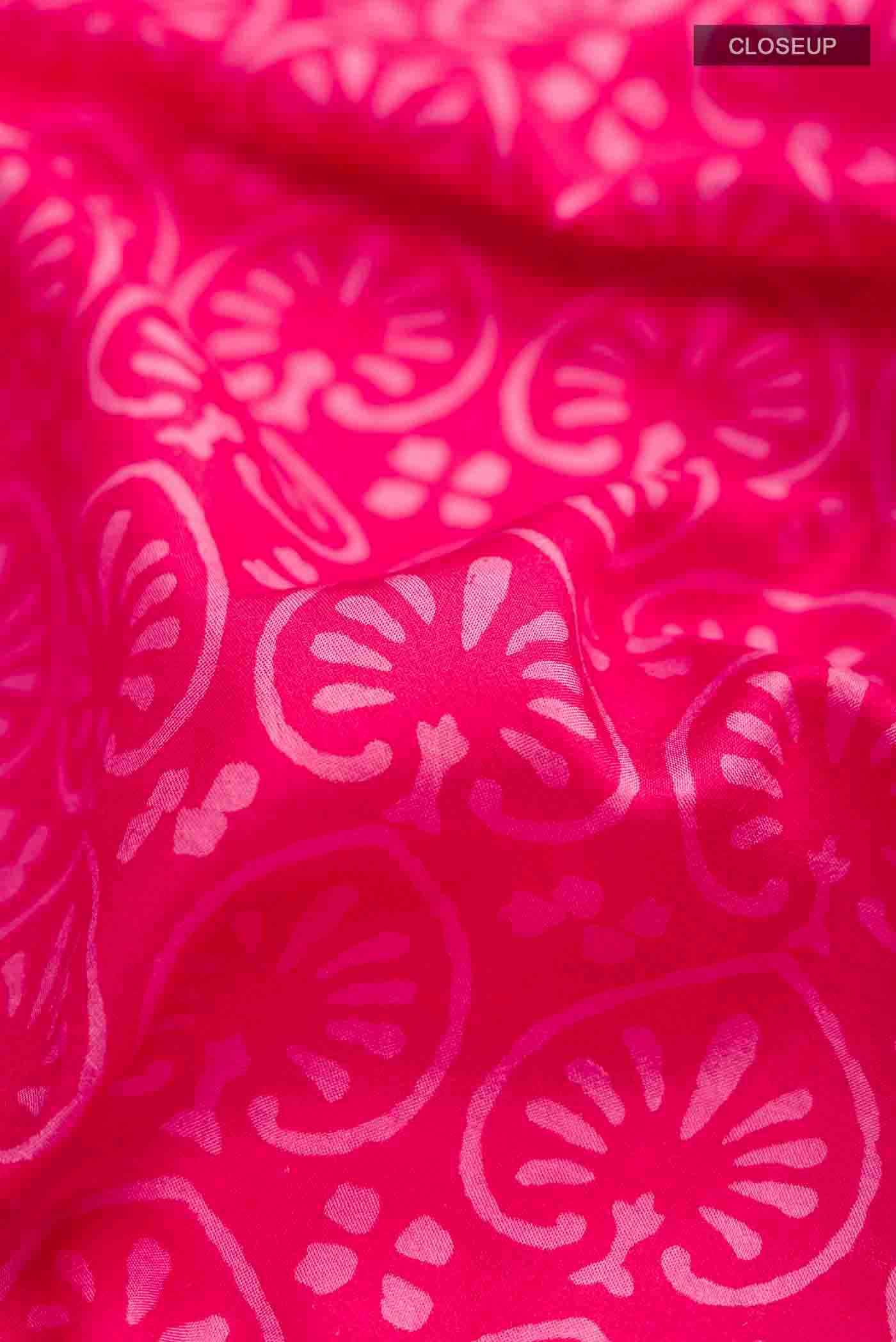 Close up of Pink Printed Silk Saree with Printed design on the body and Zari Border displaying folds