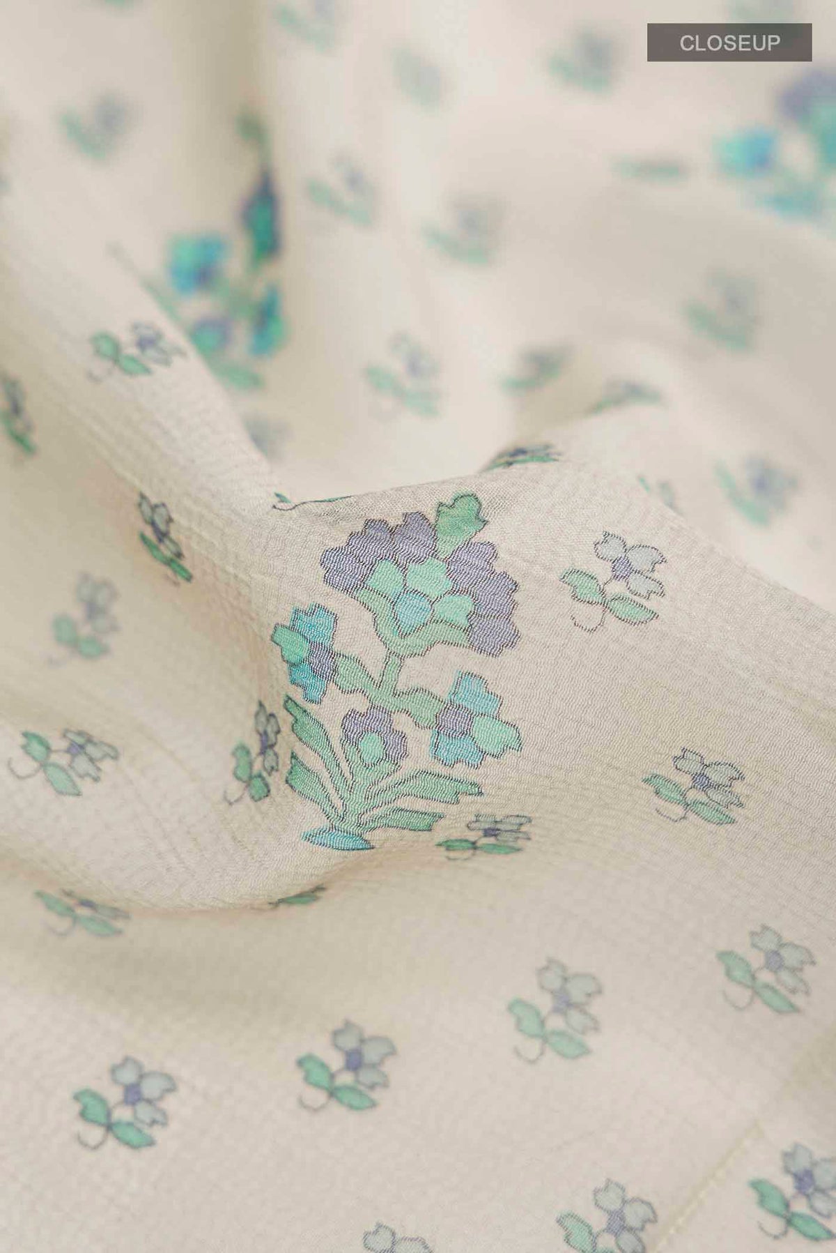 Close up of Grey Mysore Chiffon Saree with Printed design on the body and Thread Border displaying folds