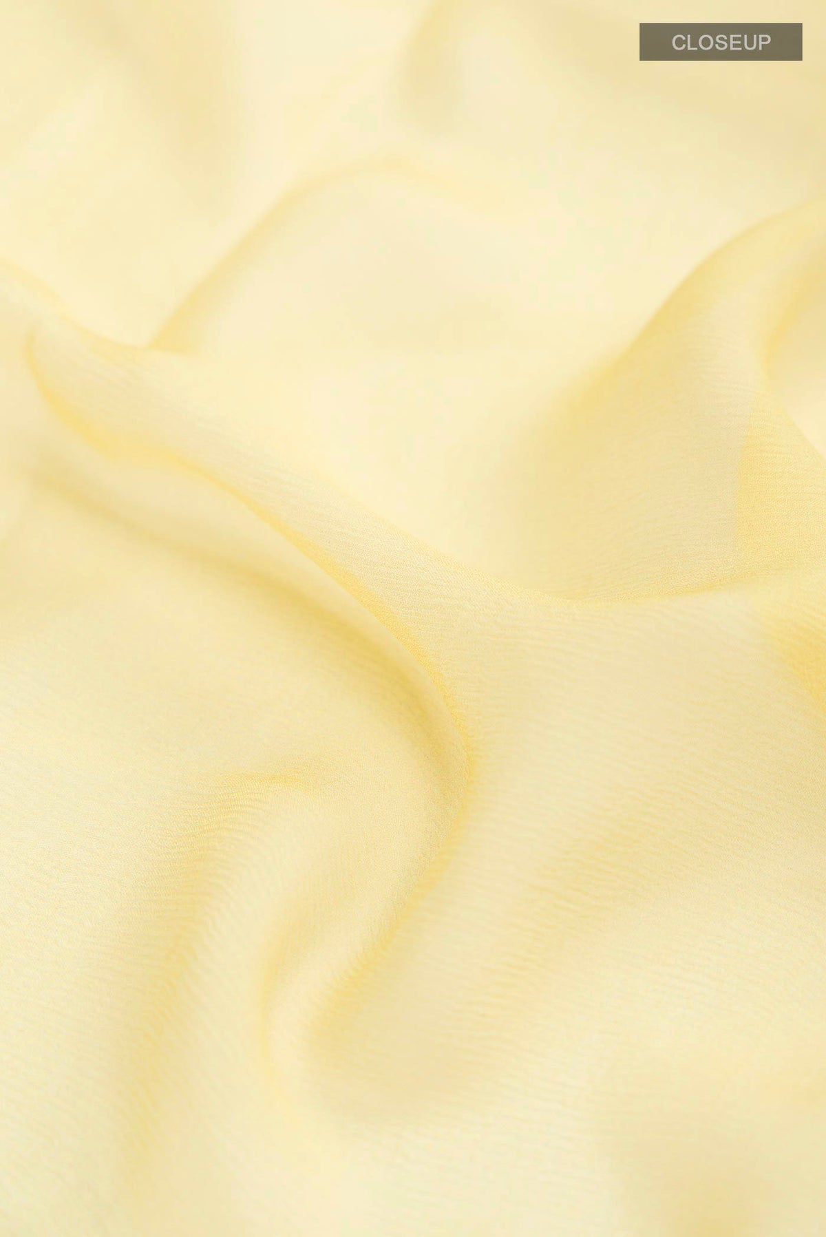 Close up of Yellow Mysore Chiffon Saree with Plain Body and Printed Border displaying folds