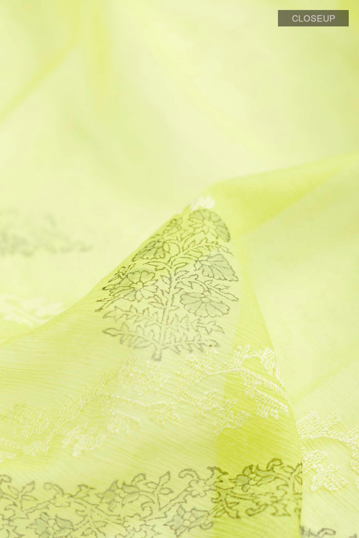 Close up of Green Mysore Chiffon Saree with Embroidery on the body and Zari Border displaying folds