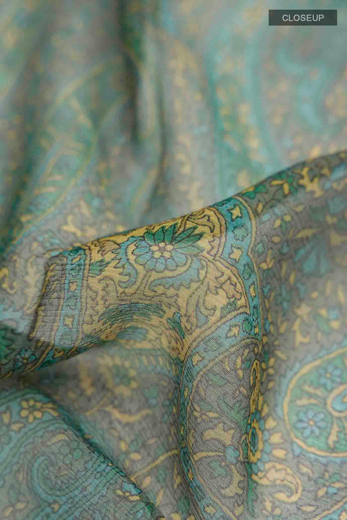 Close up of Green Mysore Chiffon Saree with Printed design on the body and Plain Border displaying folds