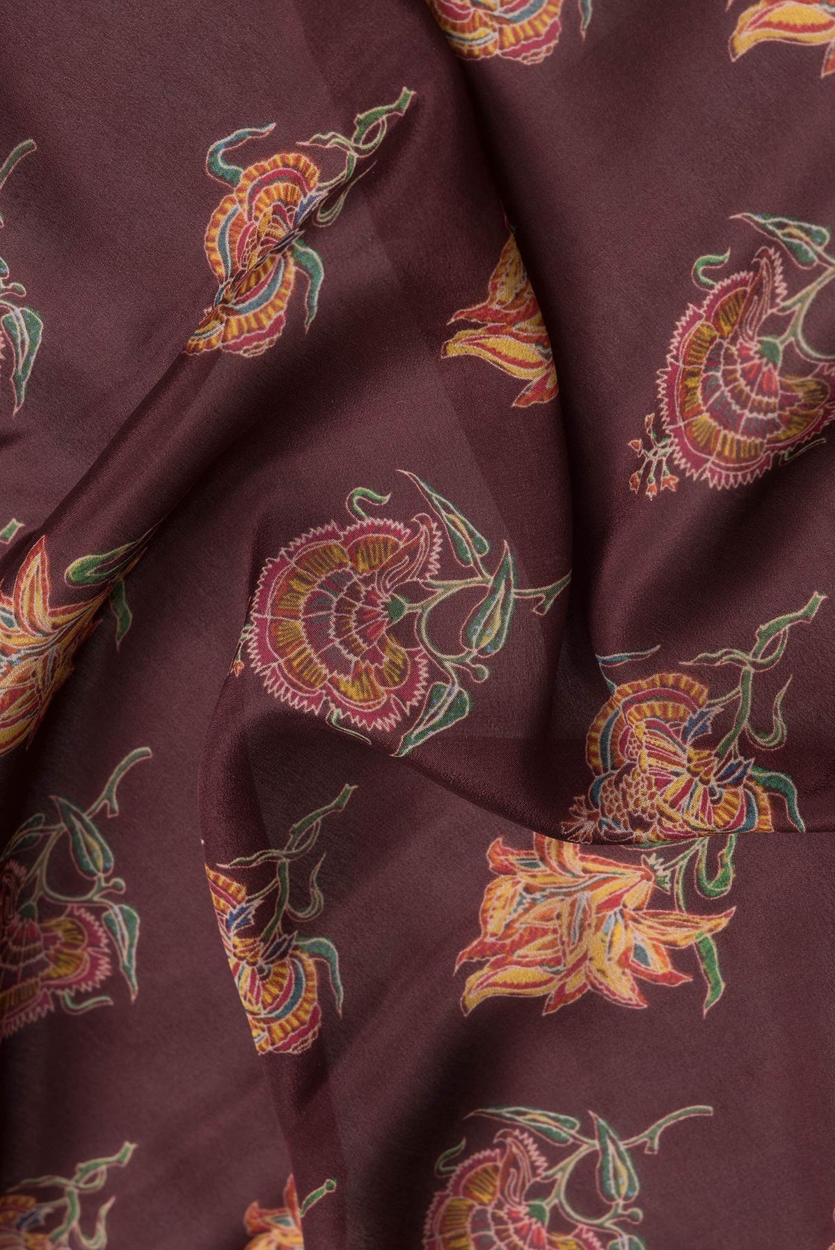 Close up of Maroon Dual Tone Crepe Saree with Printed design on the body and Zari Border.  displaying folds