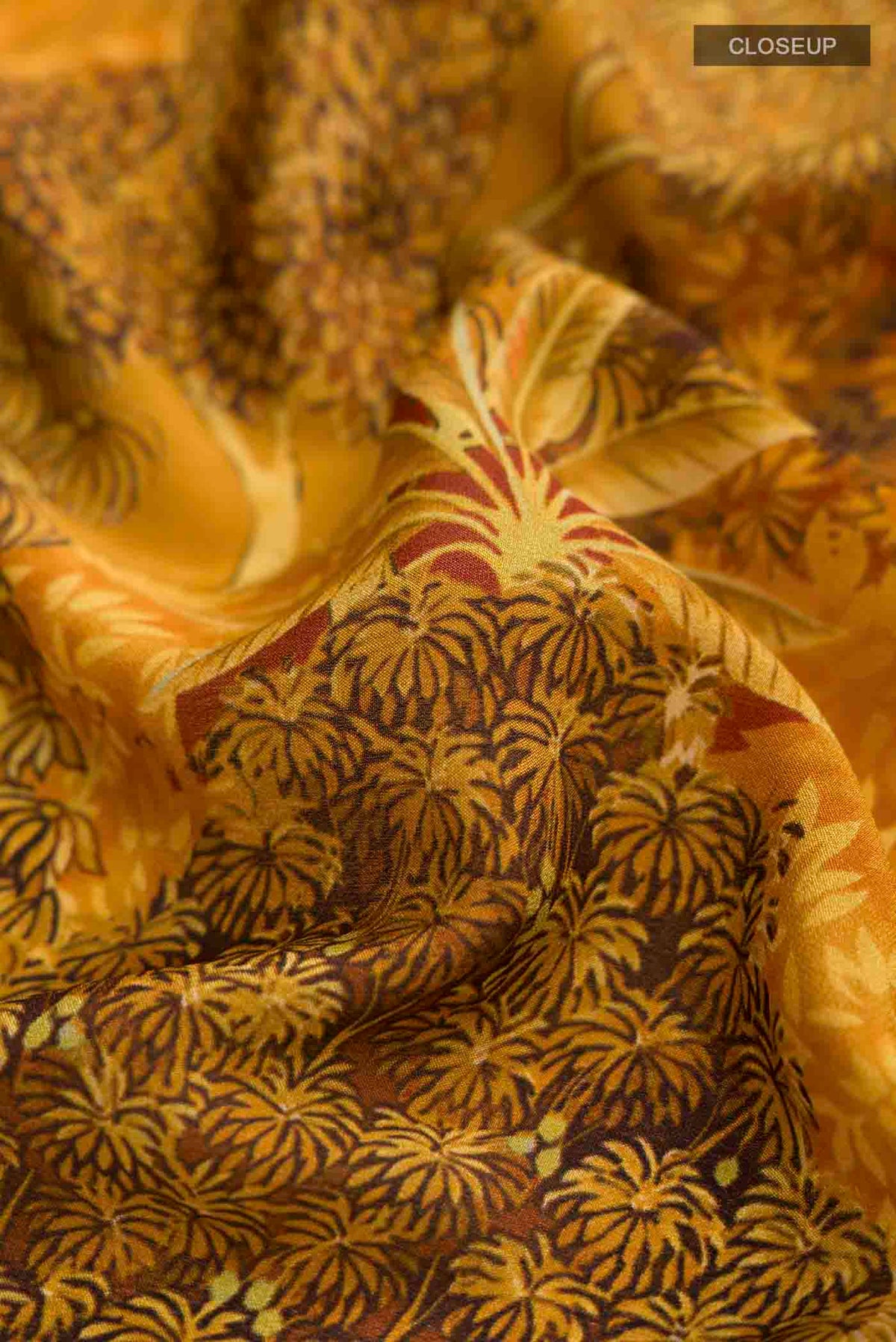 Close up of Mustard Mysore Crepe Saree with Printed design on the body and Zari Border displaying folds