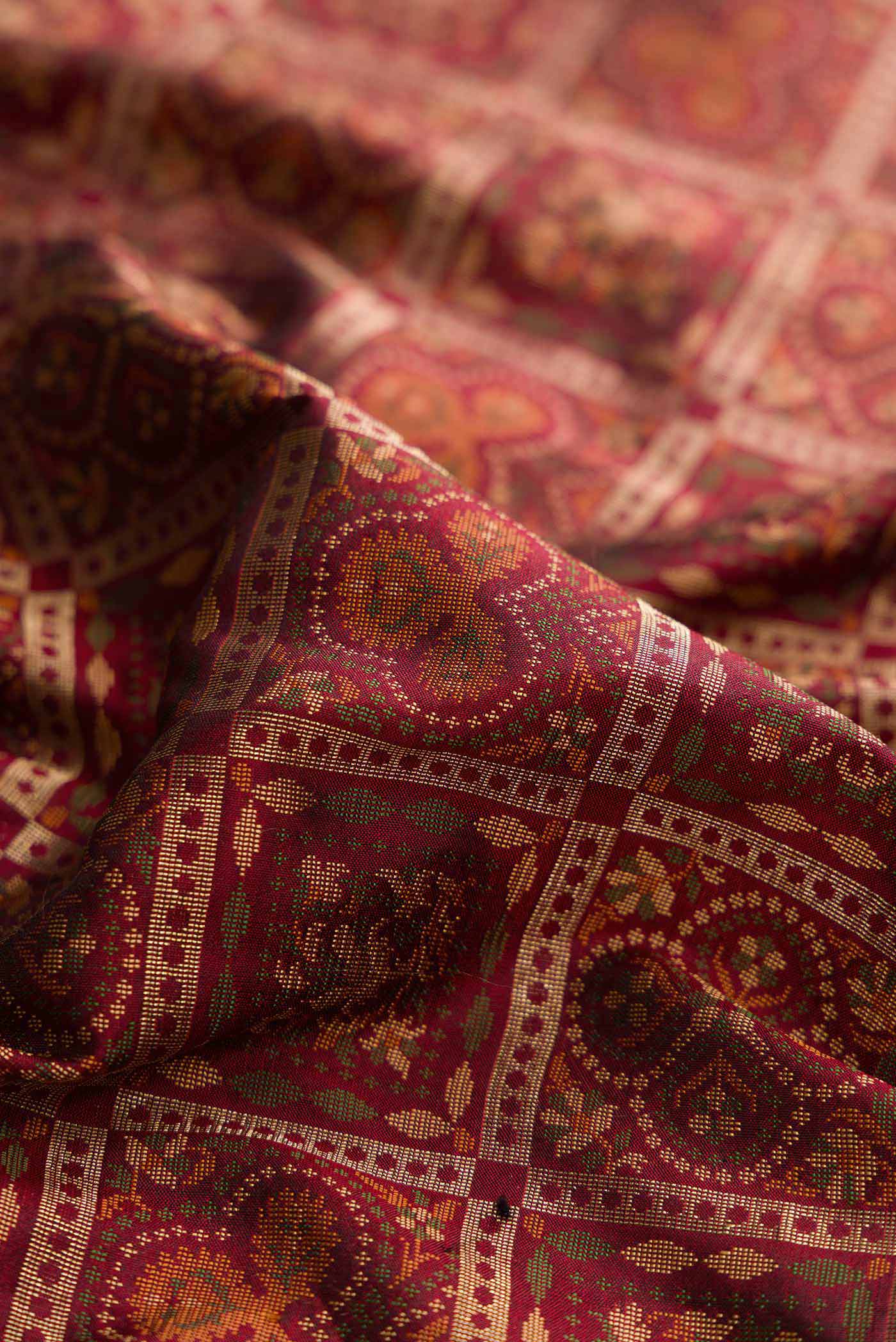 Close up of Maroon Dual Tone Banarasi Silk Saree with Zari Brocade on the body and Zari Border displaying folds