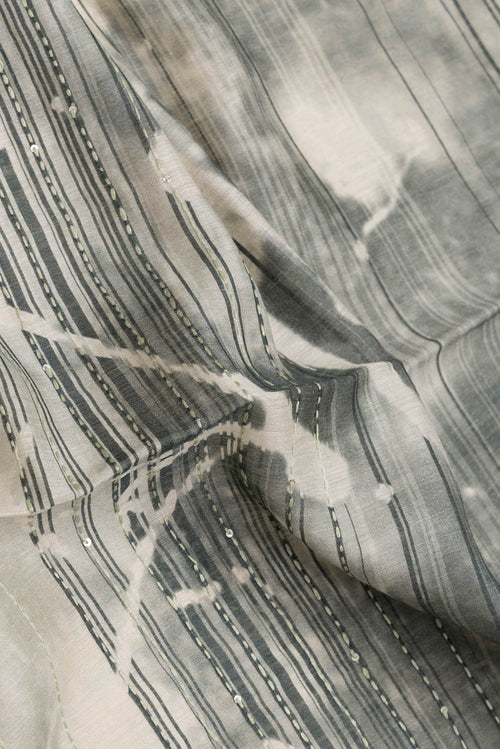 Close up of Beige Dual Tone Tussar Silk Saree with Embroidery on the body and Zari Border.  displaying folds