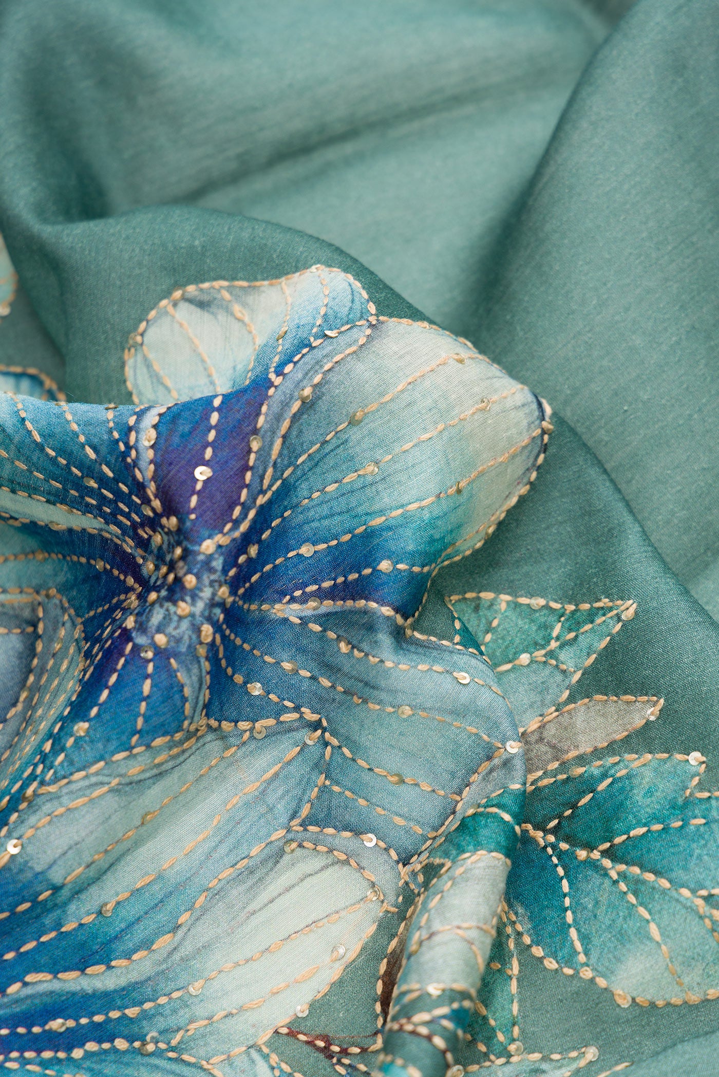 Close up of Green Dual Tone Tussar Silk Saree with Embroidery on the body and Zari Border.  displaying folds