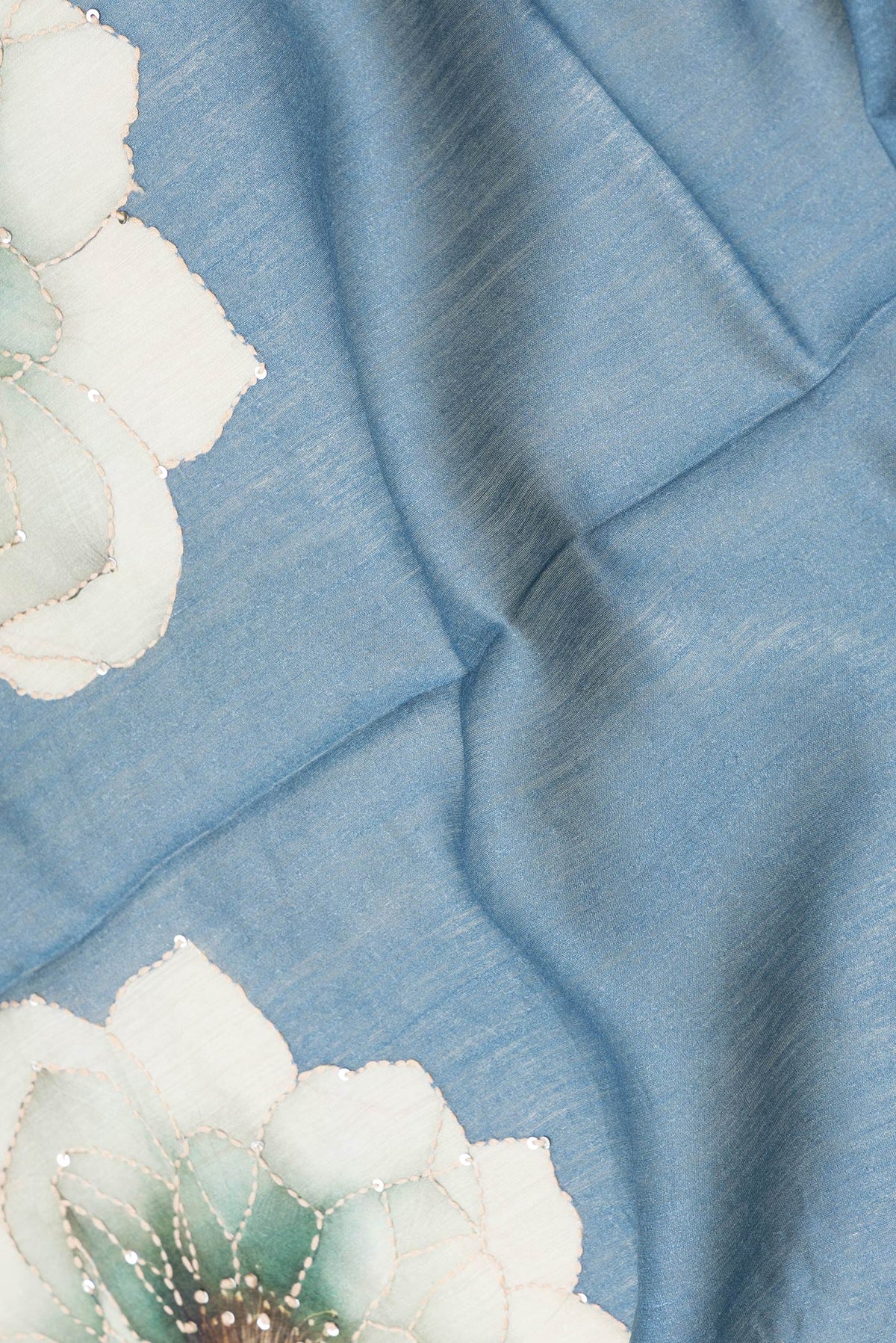 Close up of Light Blue Dual Tone Tussar Silk Saree with Embroidery on the body and Zari And Thread Border.  displaying folds