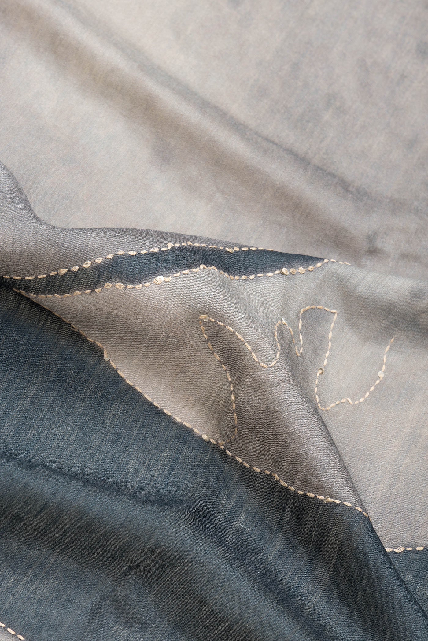 Close up of Grey Dual Tone Tussar Silk Saree with Embroidery on the body and Zari And Thread Border.  displaying folds