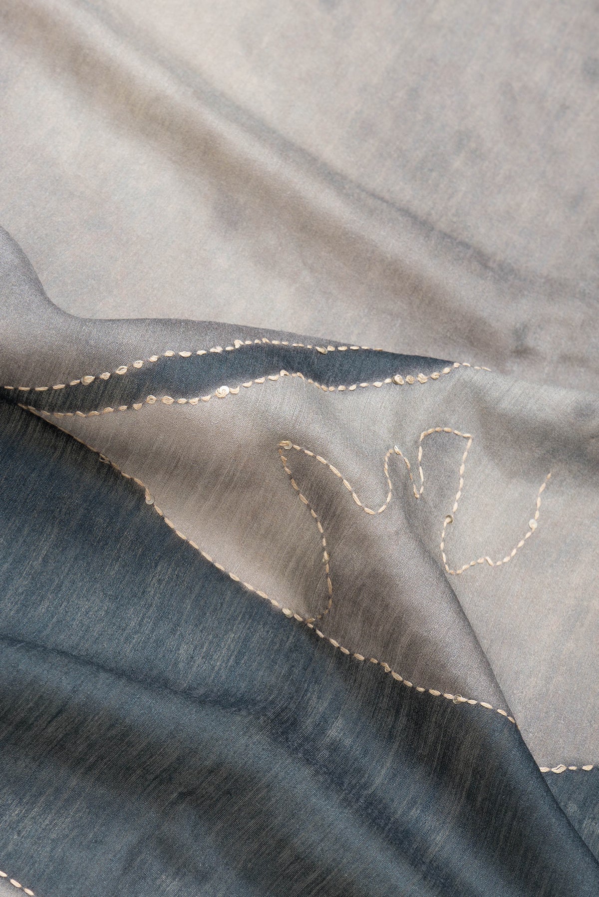 Close up of Grey Dual Tone Tussar Silk Saree with Embroidery on the body and Zari And Thread Border.  displaying folds