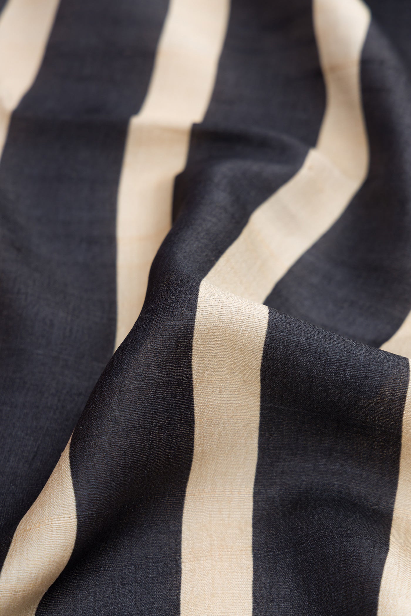 Close up of Black Dual Tone Tussar Silk Saree with Stripes on the body and Plain Border.  displaying folds