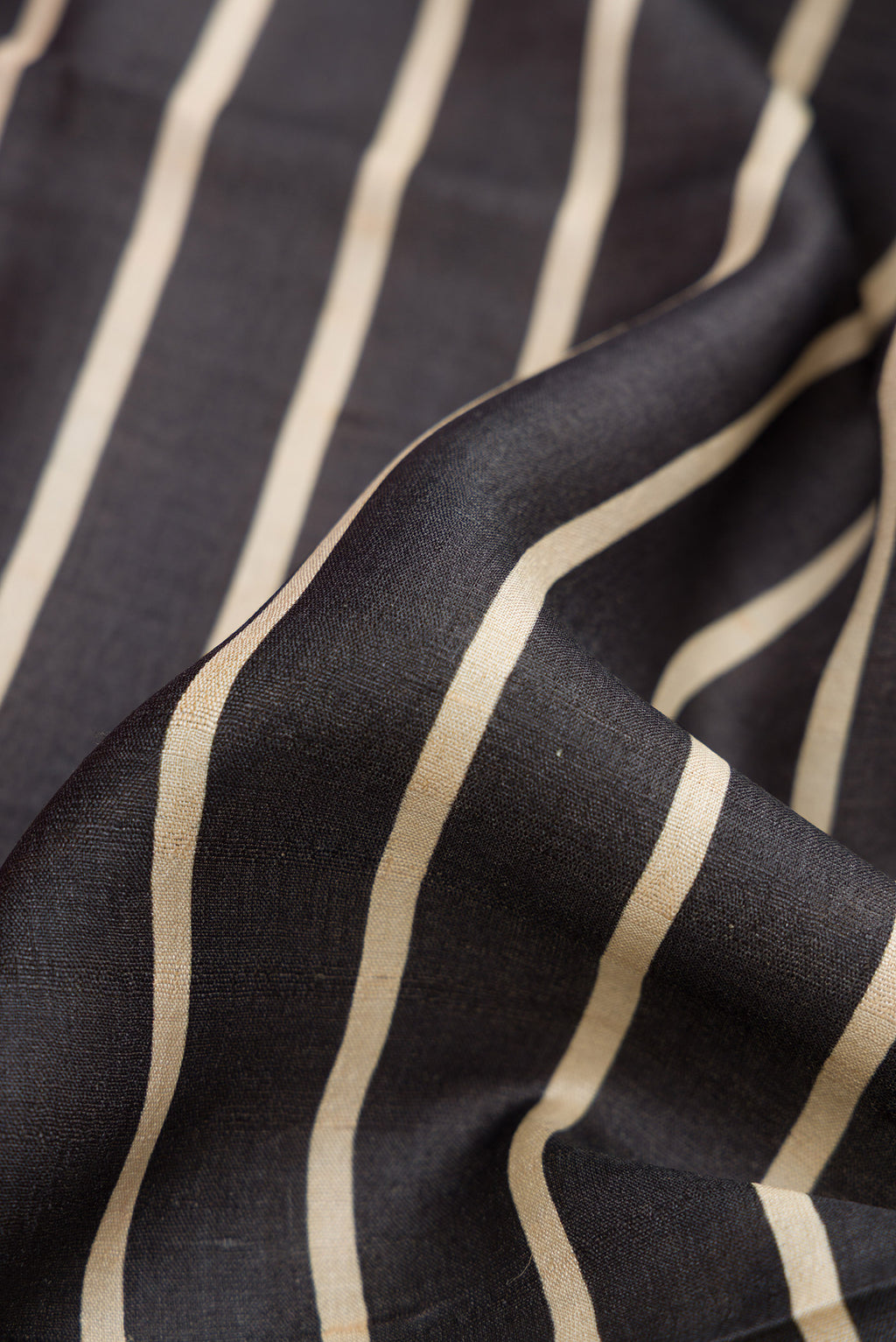 Close up of Black Dual Tone Tussar Silk Saree with Stripes on the body and Embroidery Border.  displaying folds
