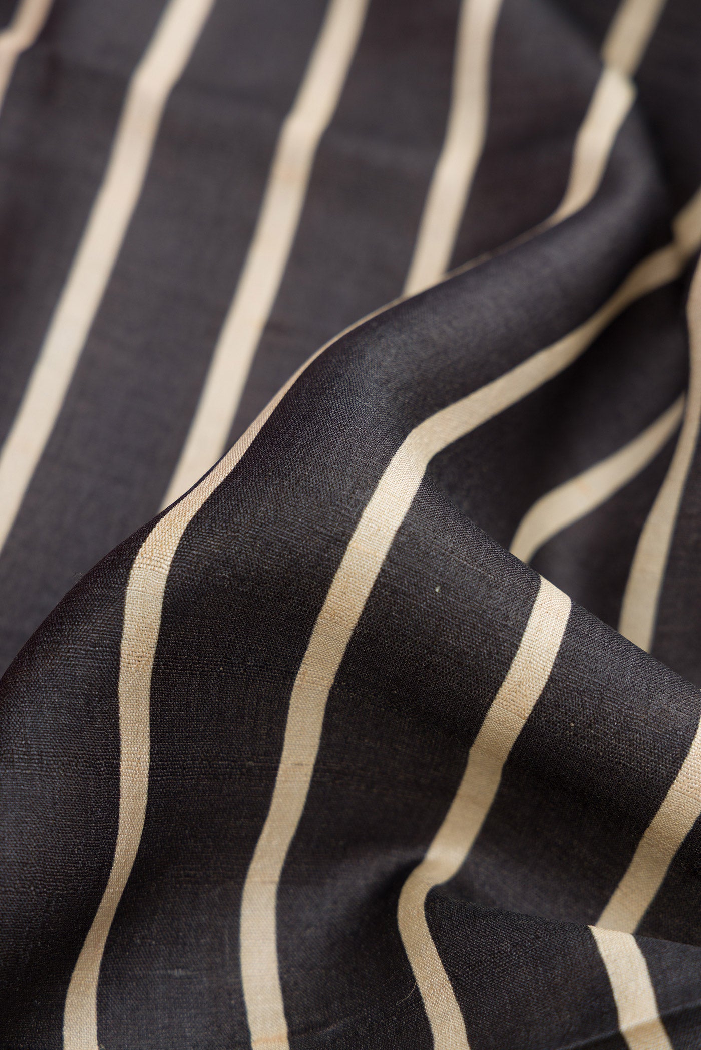 Close up of Black Dual Tone Tussar Silk Saree with Stripes on the body and Embroidery Border.  displaying folds