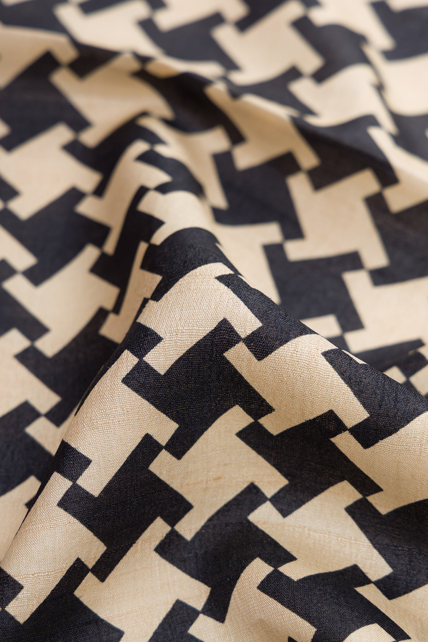 Close up of Black Dual Tone Tussar Silk Saree with Printed design on the body and Embroidery Border.  displaying folds