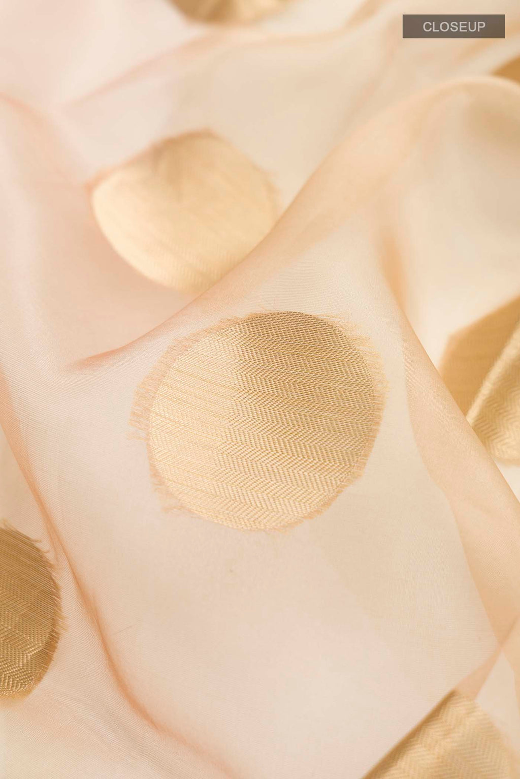 Close up of Sandal Organza Silk Saree with Zari Butta on the body and Zari Border displaying folds