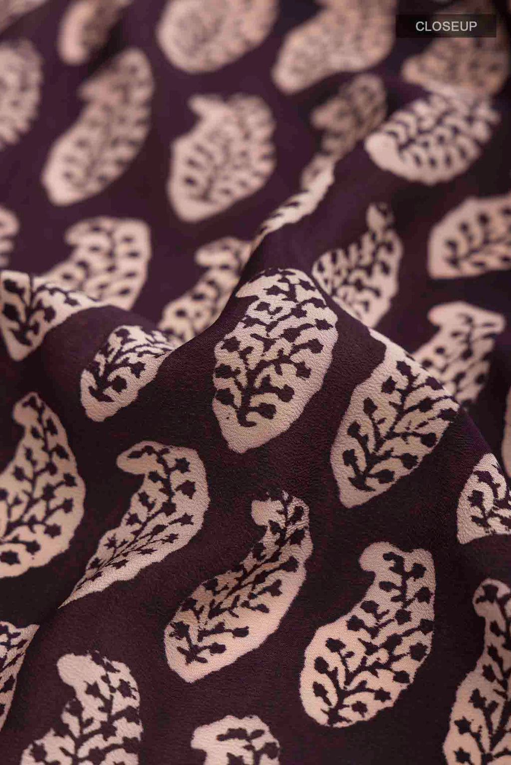 Close up of Black Mysore Crepe Saree with Printed design on the body and Printed Border displaying folds