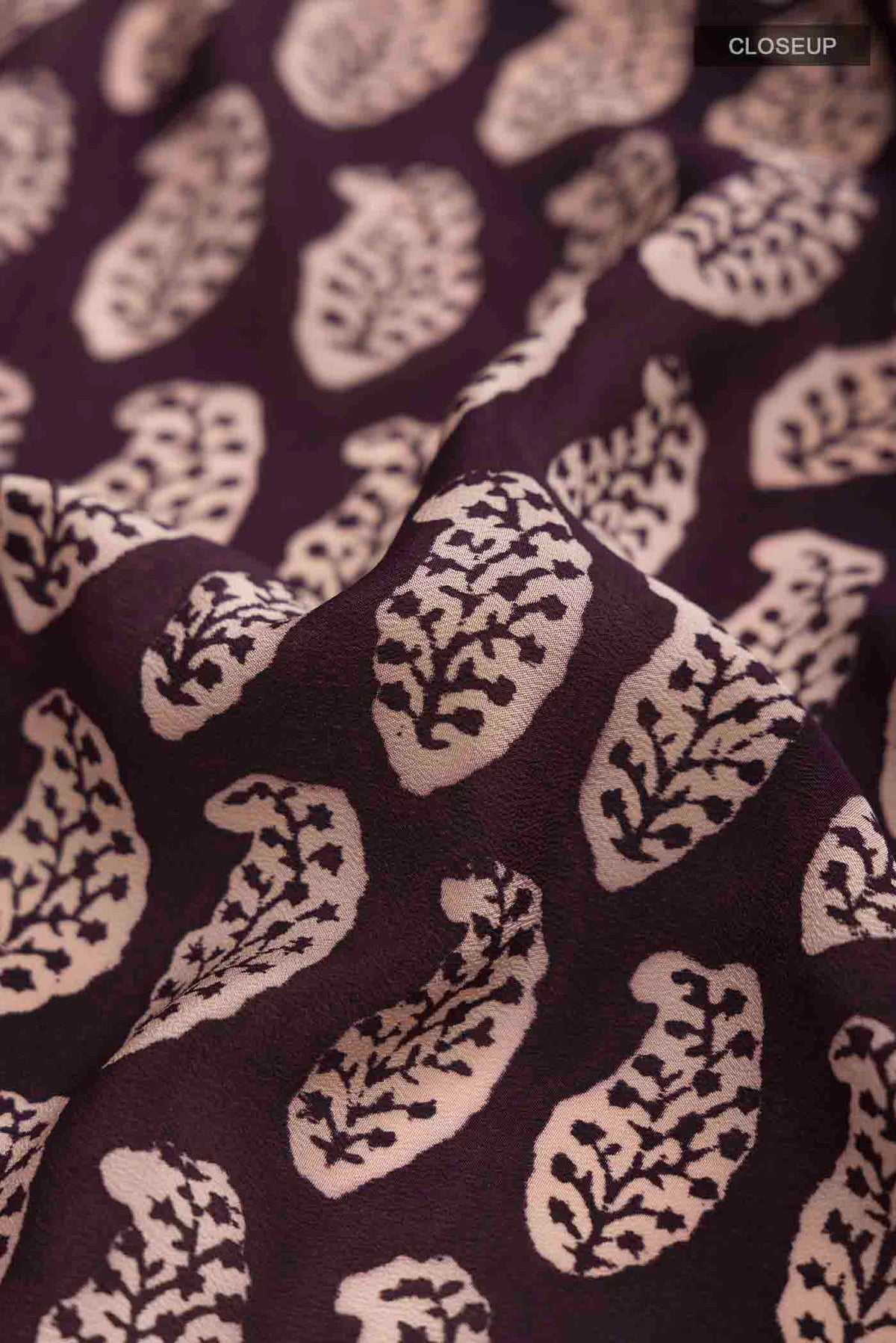 Close up of Black Mysore Crepe Saree with Printed design on the body and Printed Border displaying folds