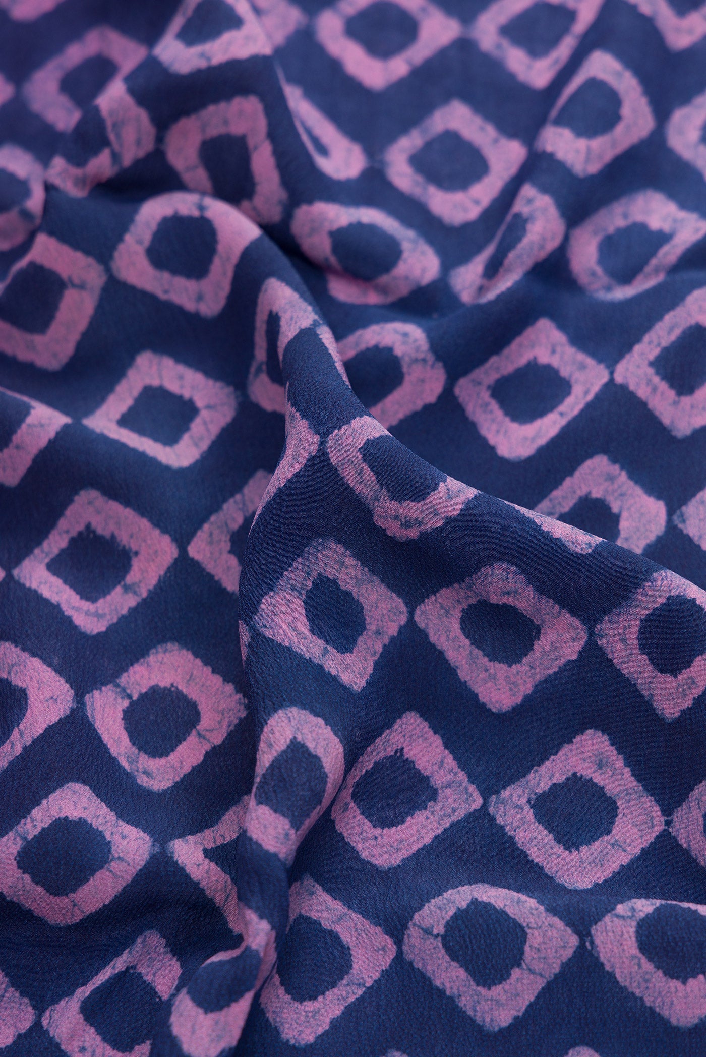Close up of Royal Blue Dual Tone Mysore Crepe Saree with Printed design on the body and Printed Border.  displaying folds