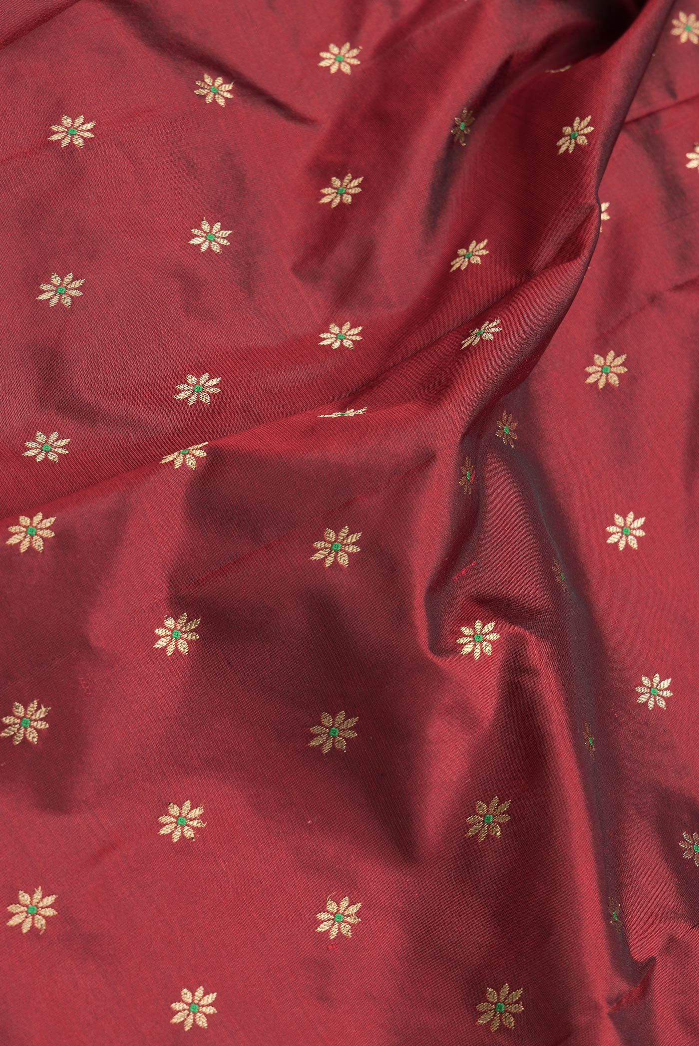 Close up of Maroon Dual Tone Paithani Silk Saree with Zari And Thread Butta on the body and Zari Border.  displaying folds