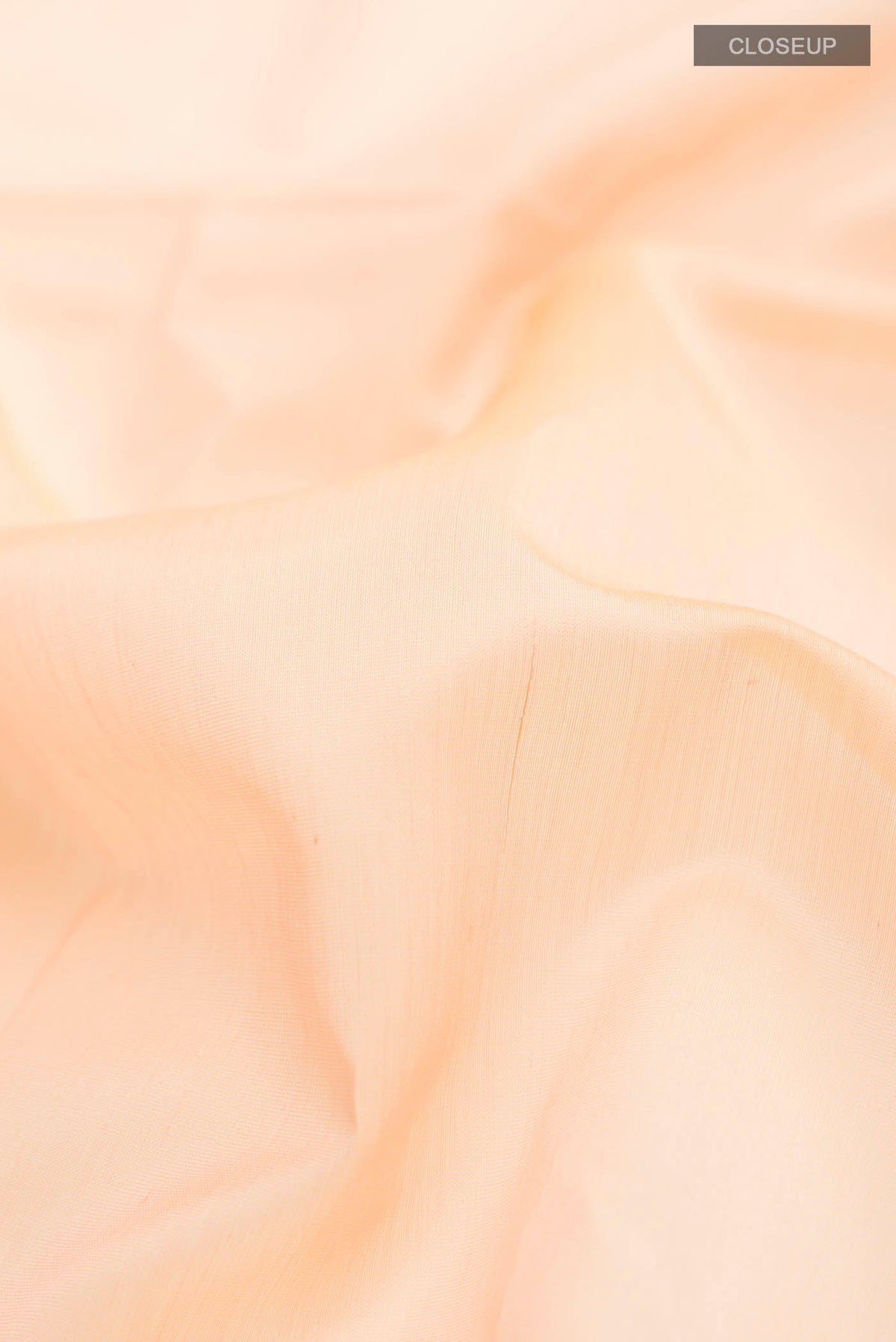 Close up of Peach Maheshwari Silk Cotton Saree with Plain Body and Zari Border displaying folds